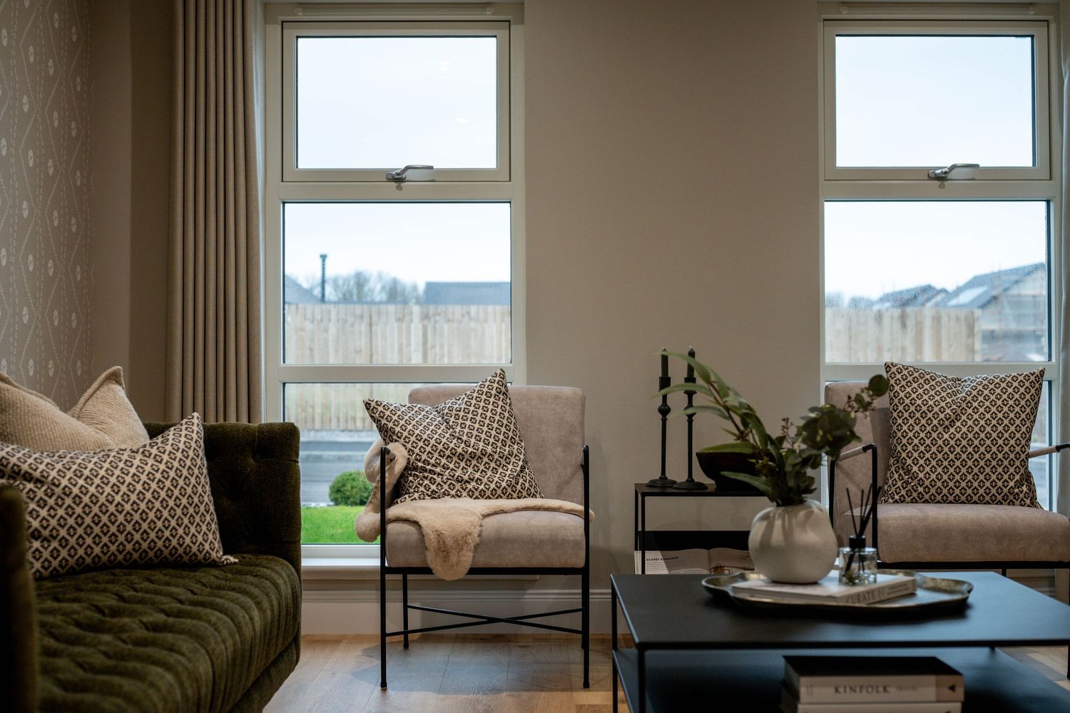 Contemporary living room with panoramic windows offering scenic views and comfortable neutral-toned seating.