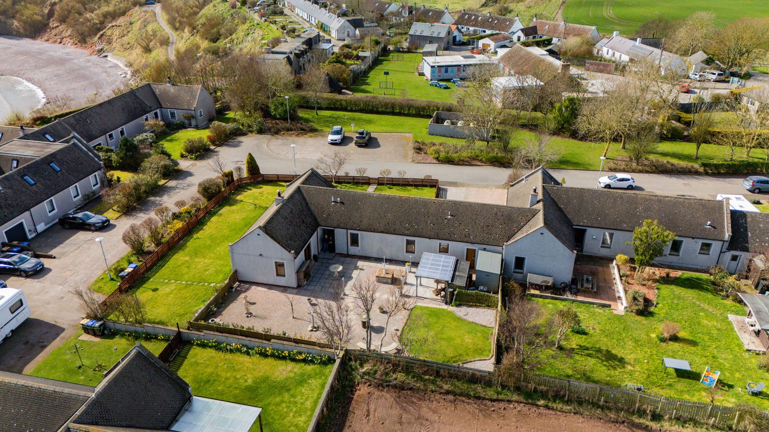 Aerial drone view of modern residential homes with spacious backyards in a quiet suburban neighborhood.