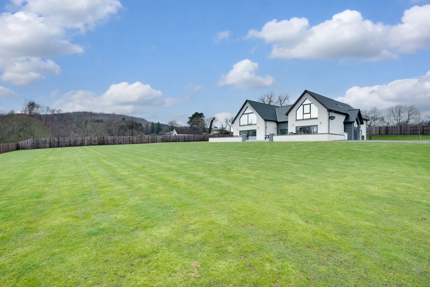 A series of panoramic views showing a large green lawn with a white farmhouse and barn buildings against a blue sky.