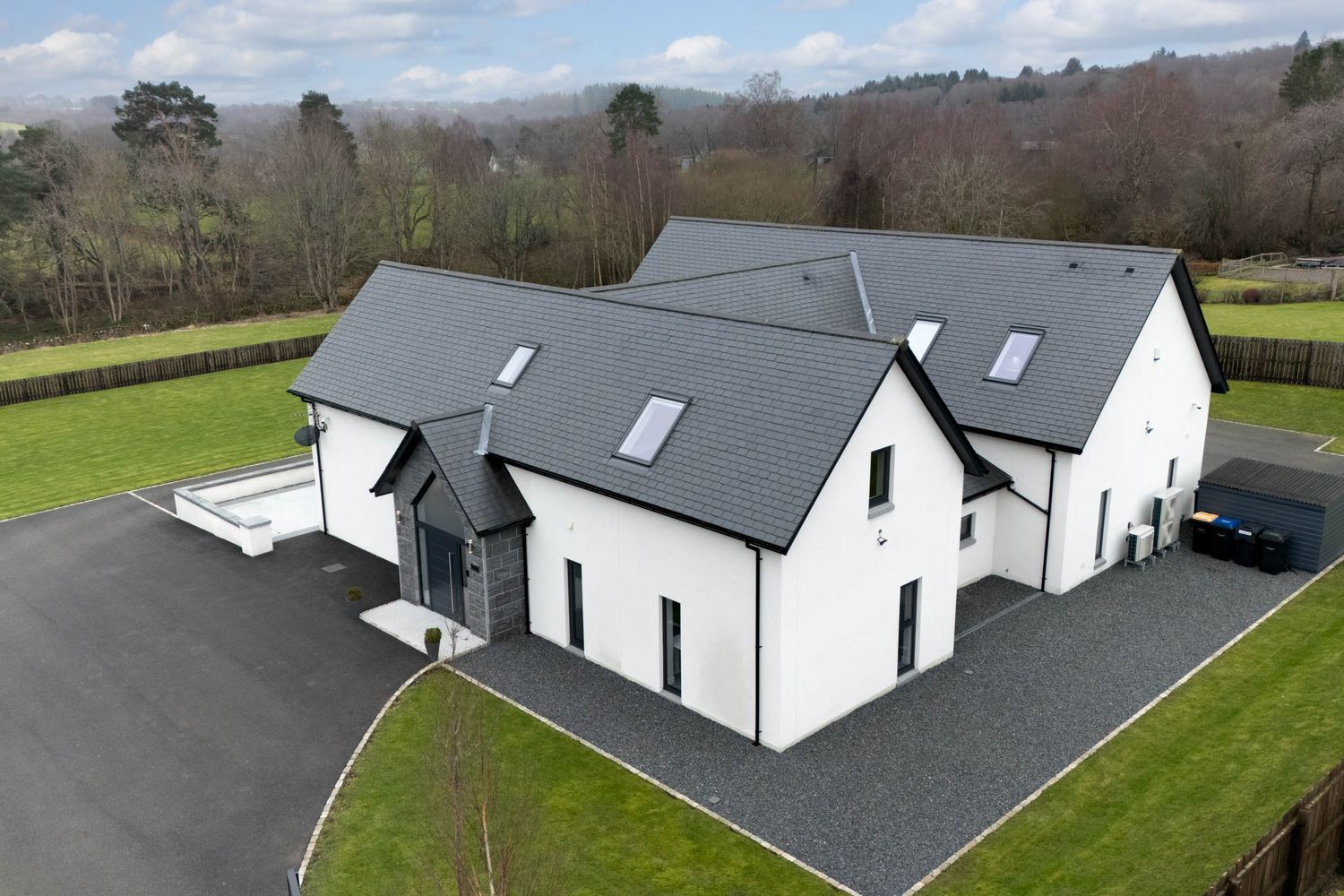 Modern white farmhouse style home with black roof shown from multiple angles in a rural hillside setting.