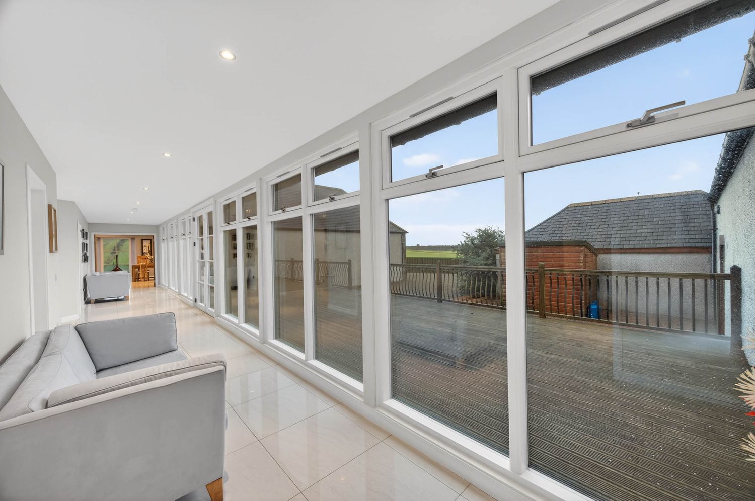 Large windows spanning across white walls bring natural light into a modern interior space.