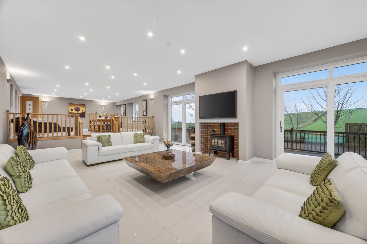 Spacious living area with plush seating and decorative green accents.