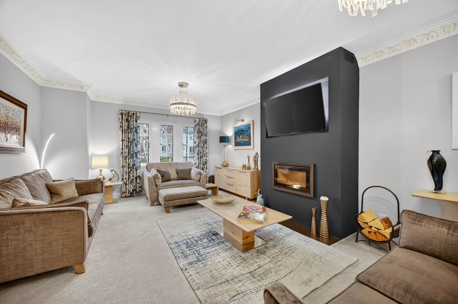 Living room featuring a black fireplace wall, comfortable seating, and ambient lighting.