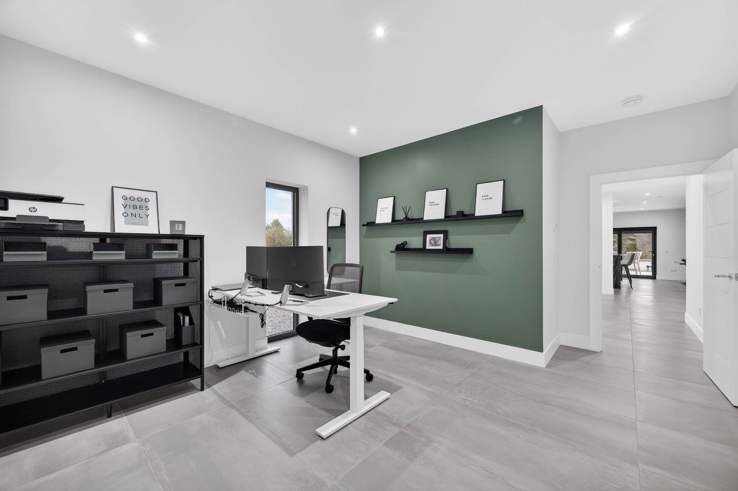 Modern minimalist interior design featuring recessed lighting and sleek black and white finishes throughout connected spaces.