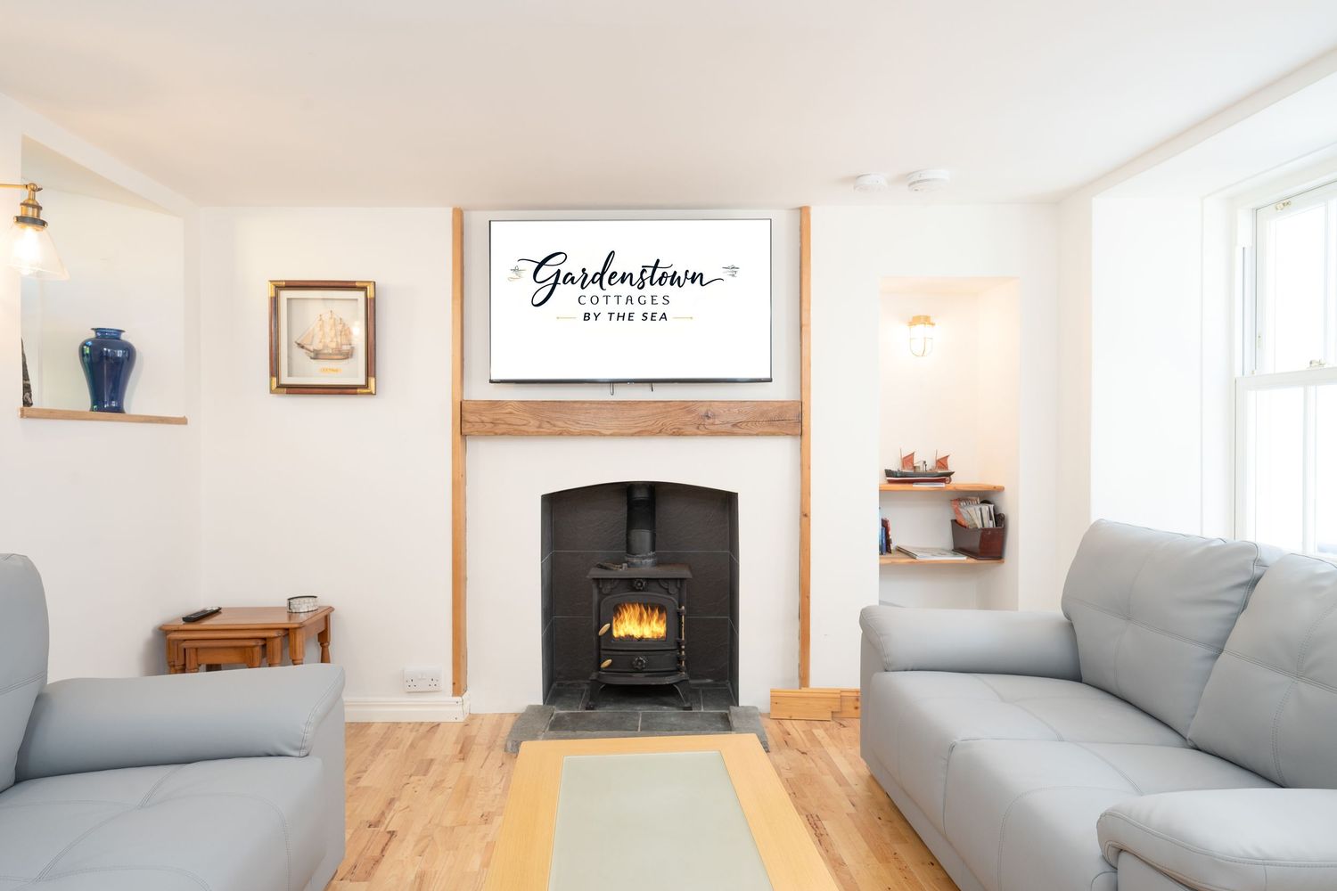 Cozy living room with grey sofas, wooden floors and traditional fireplace featuring Gordonstoun sign.
