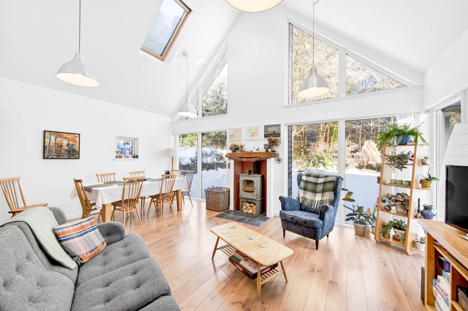 Modern open concept living room with white walls, hardwood floors and contemporary furniture.