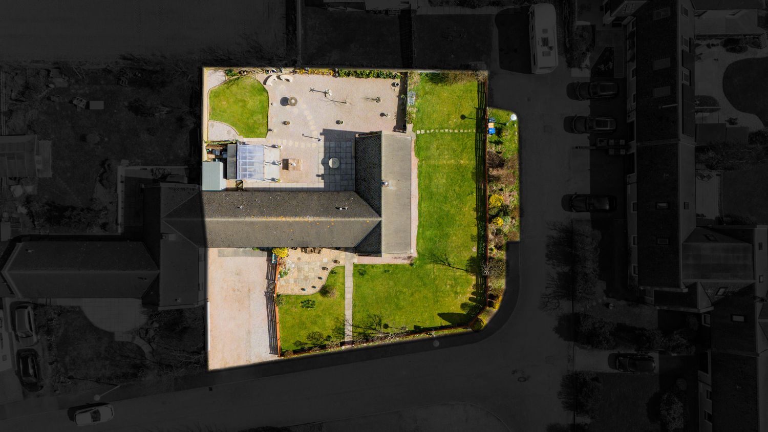 Aerial drone view of a modern house with a manicured lawn and landscaping seen from directly above.