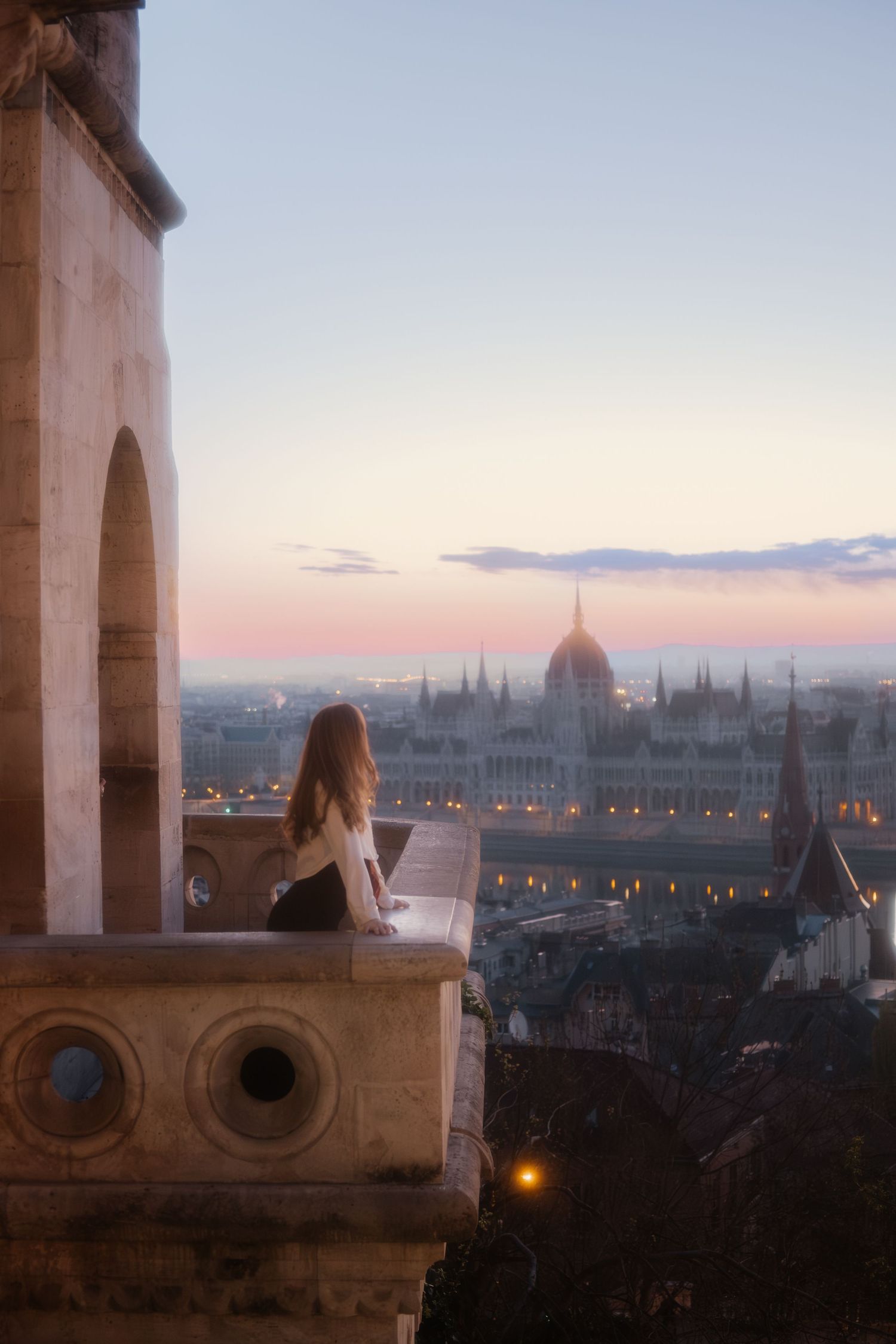 Frau steht auf Balkon bei Sonnenaufgang