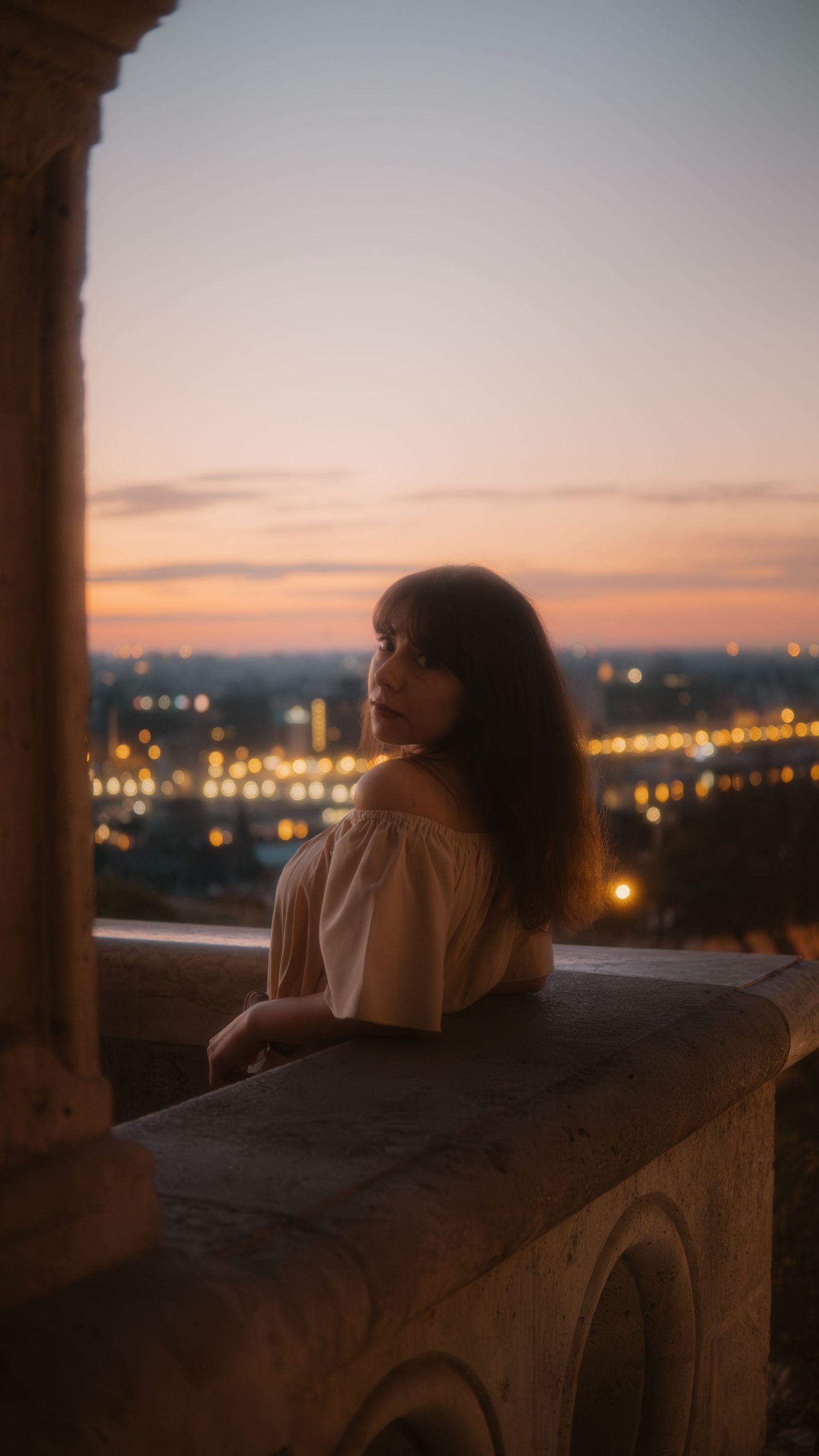 Frau lehnt romantisch am Balkon