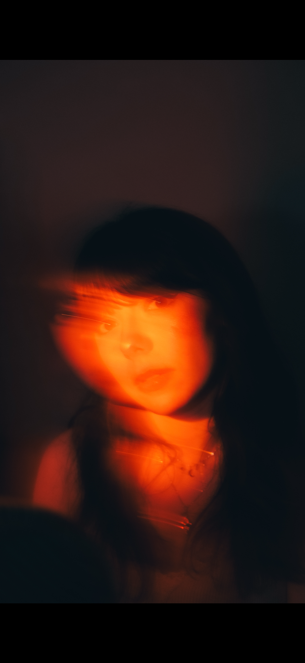 verschwommenes Bild von Frau mit orangen Licht