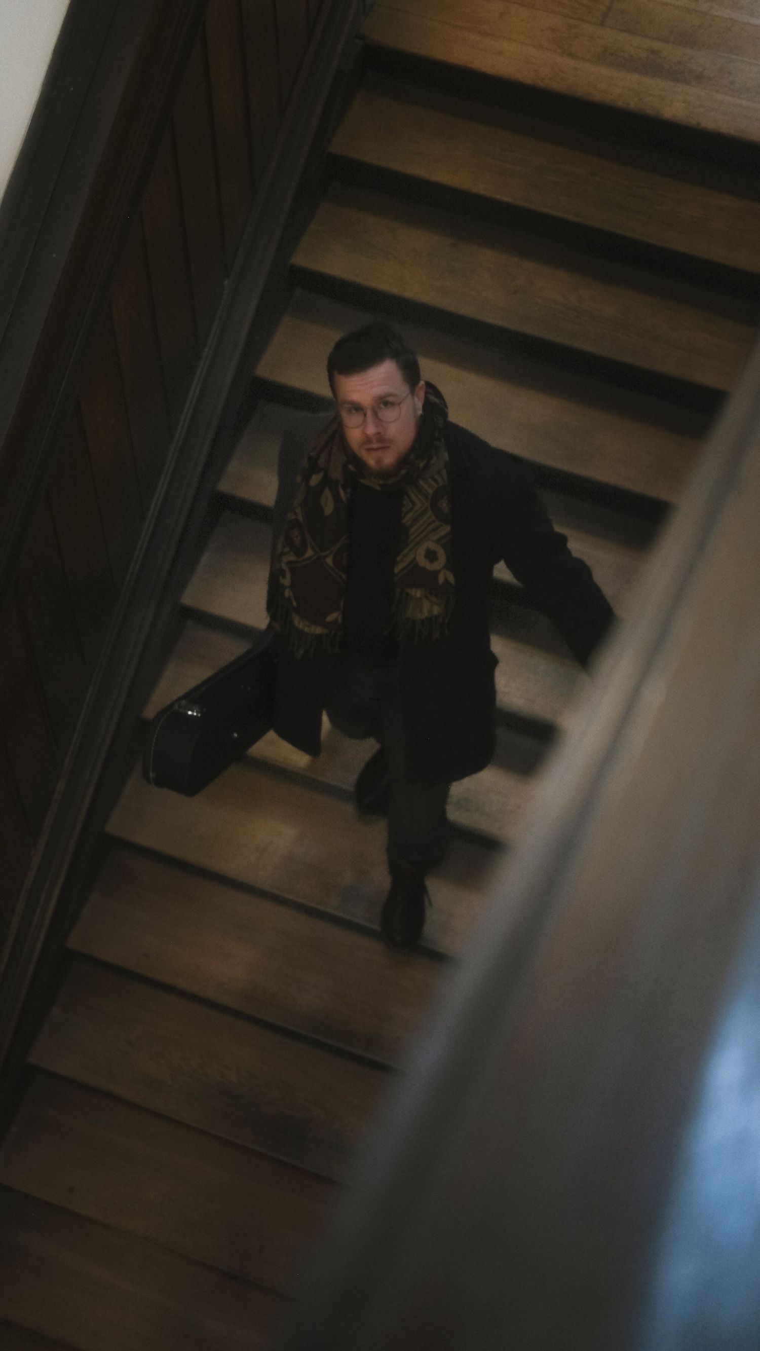 Mann mit Gitarre läuft Treppe runter