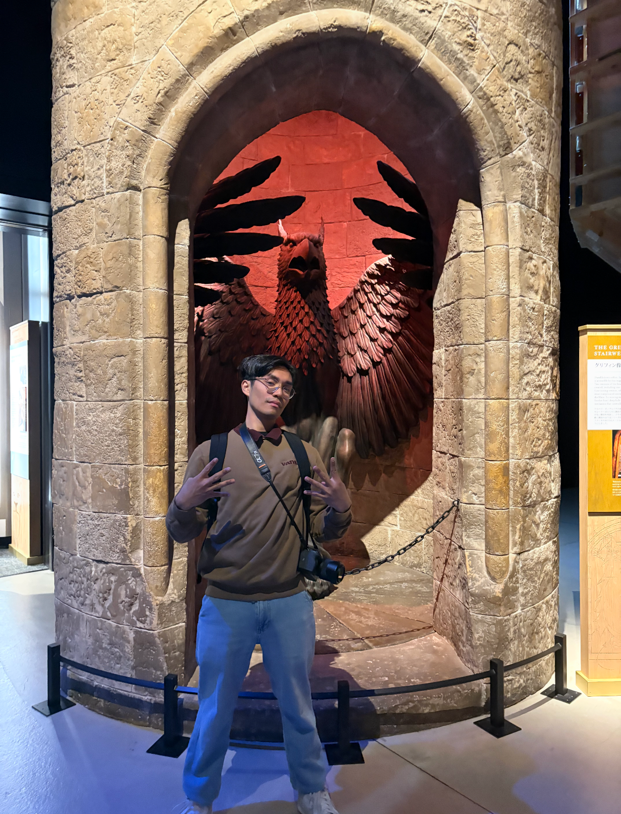 Visitor posing in front of a large phoenix mural at the Harry Potter Studio Tour.