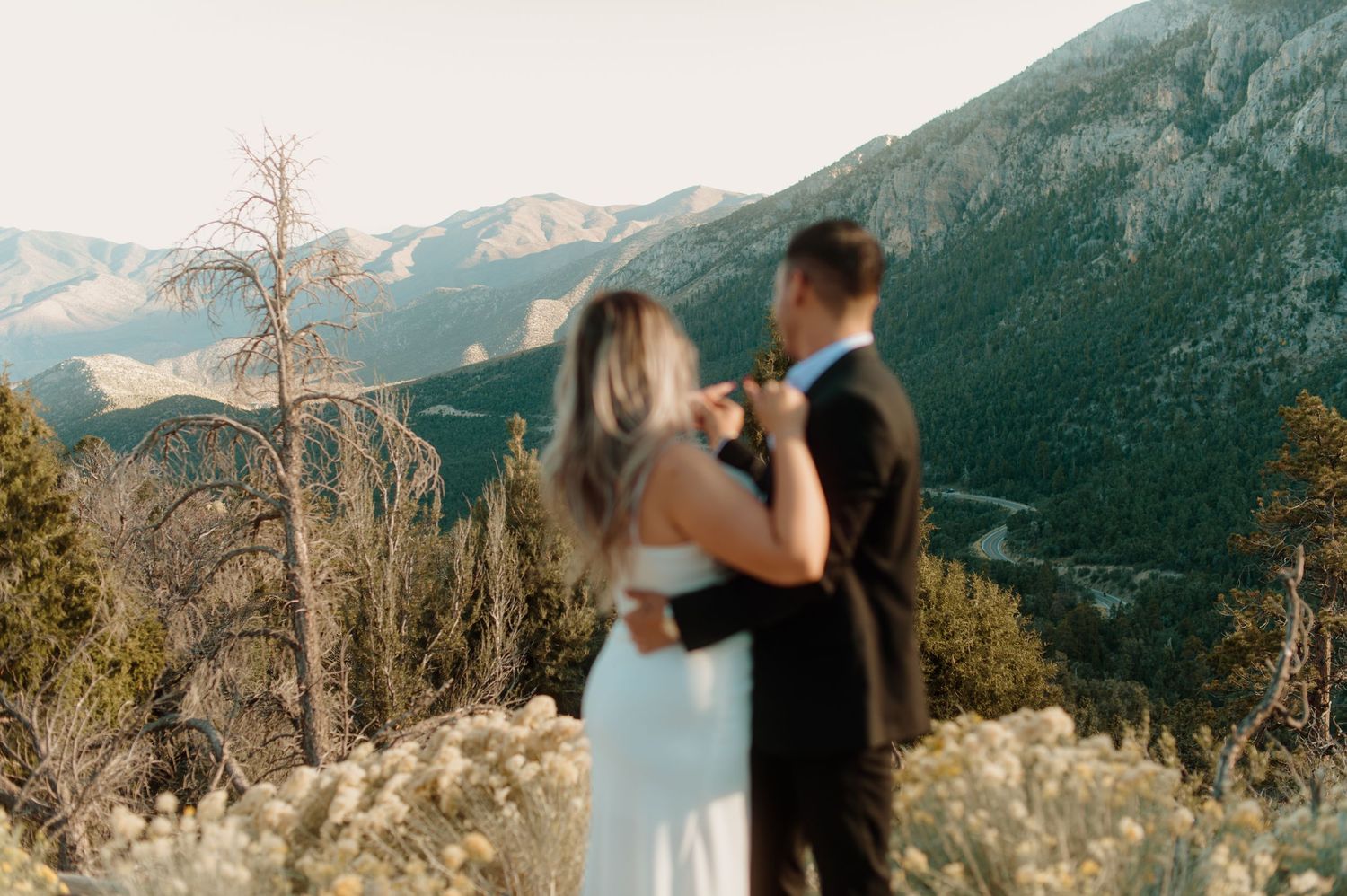 Bride and groom share a first dance with stunning mountain and valley scenery behind them.