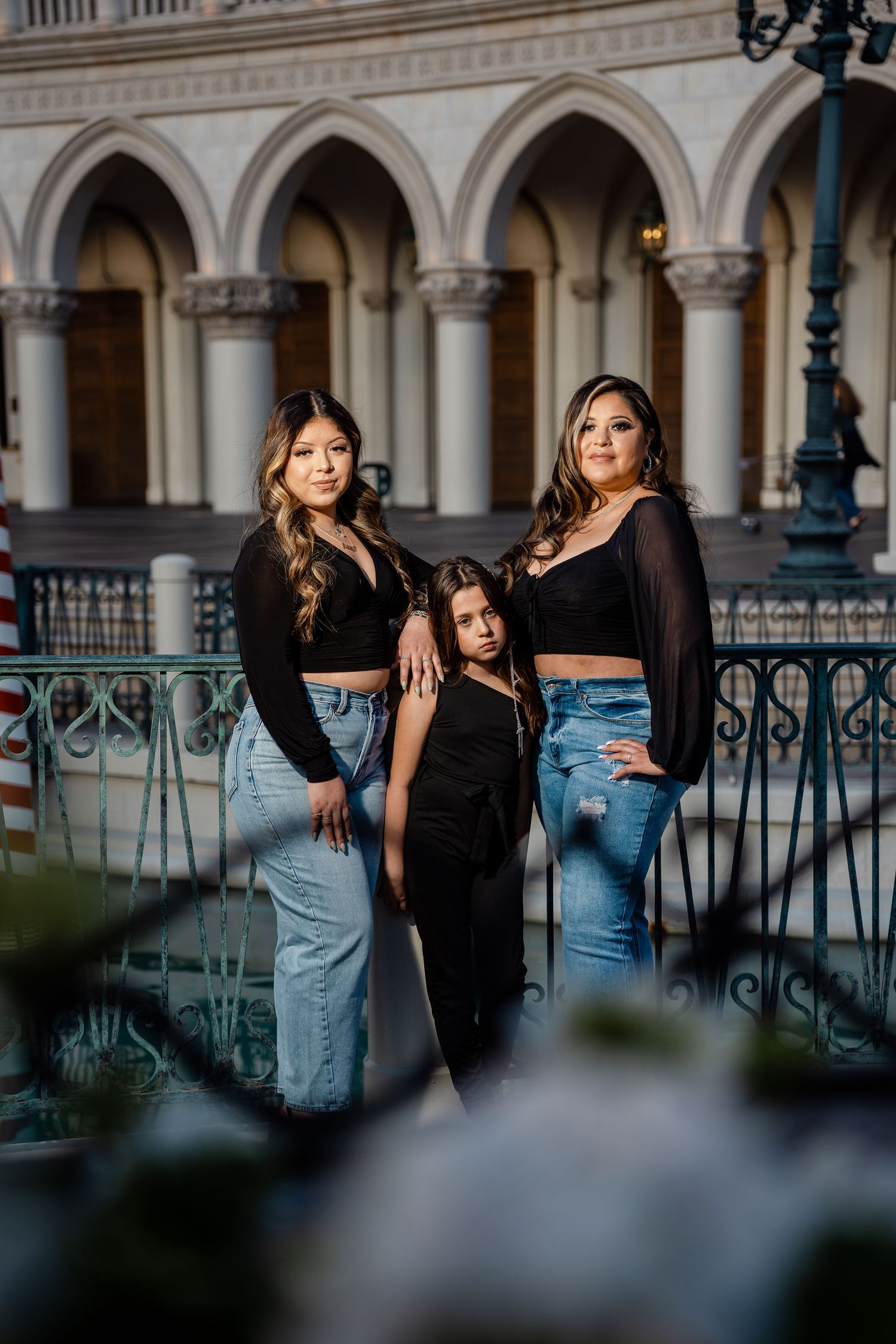 Three females in black tops and jeans pose elegantly at The Venetian resort in Las Vegas.