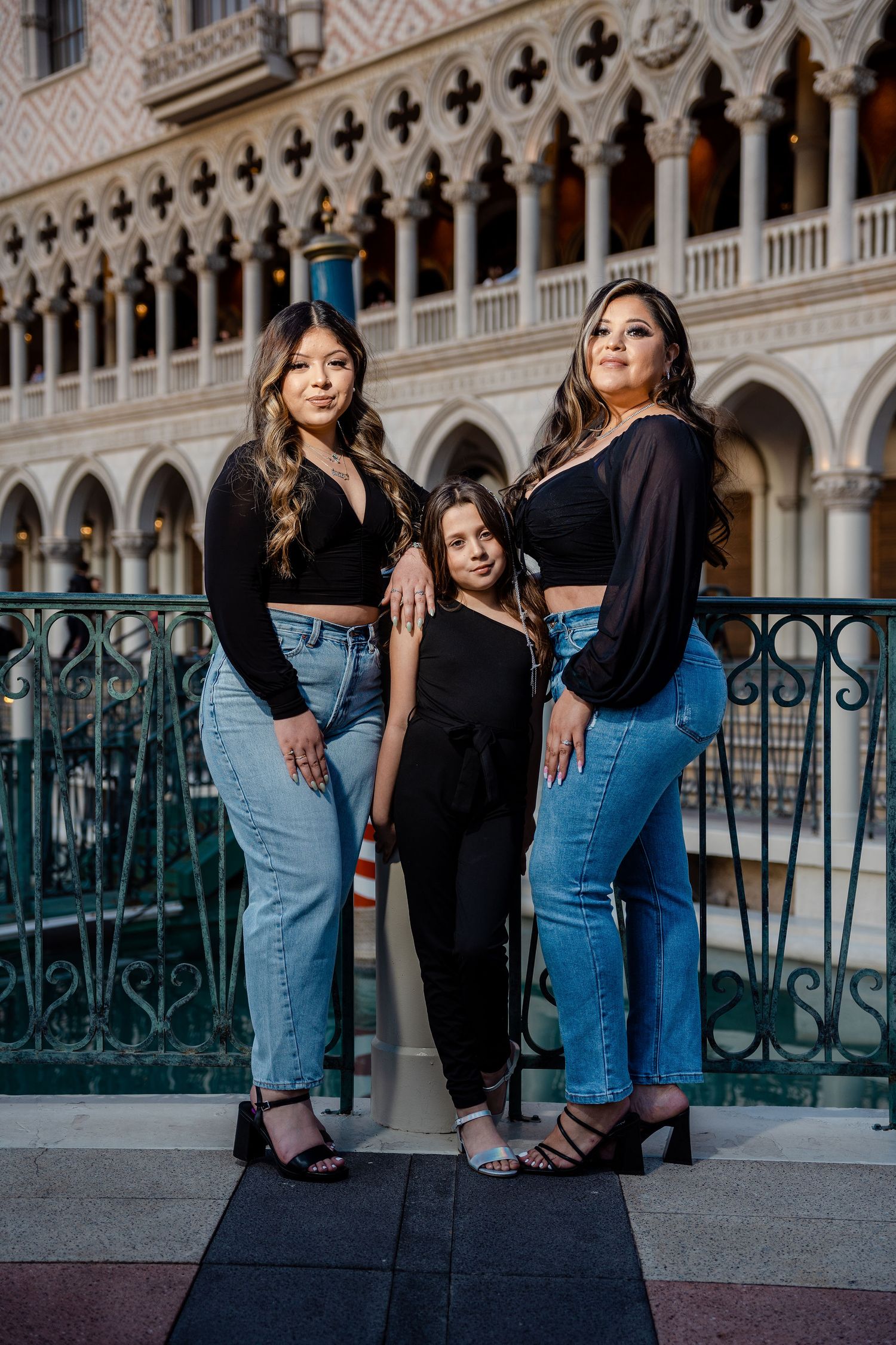 Three females in matching black tops and jeans pose confidently at The Venetian in Las Vegas.