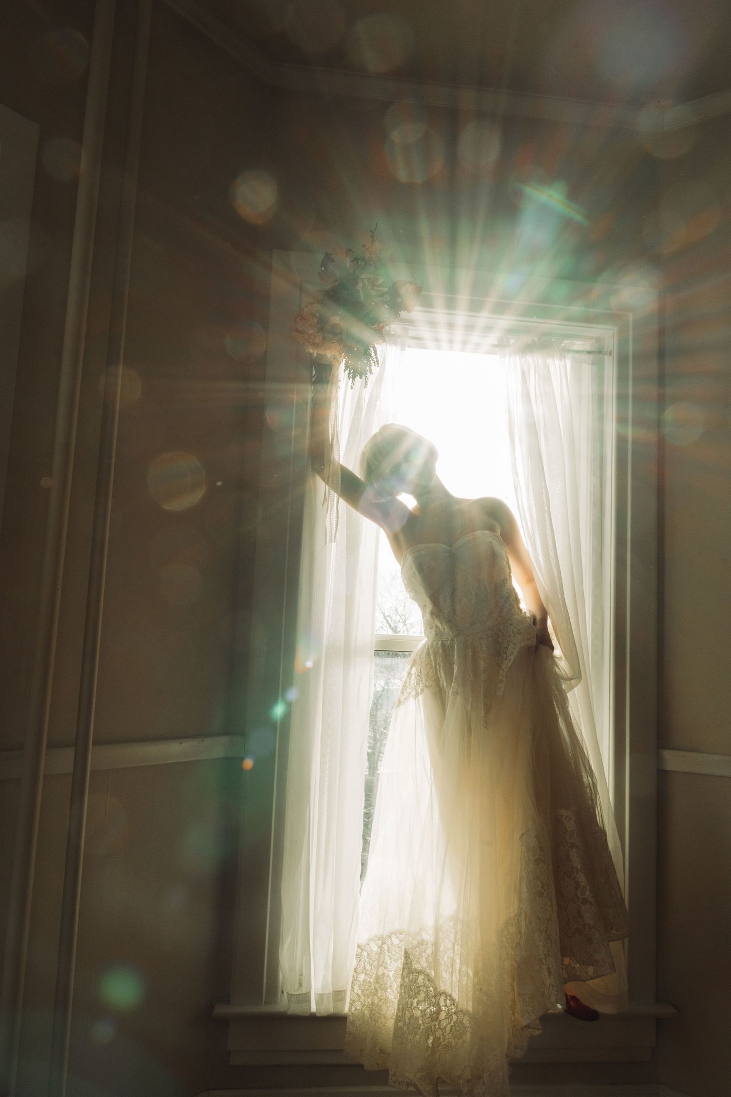 Ethereal silhouette through sheer curtains with dramatic sunlight and lens flares.