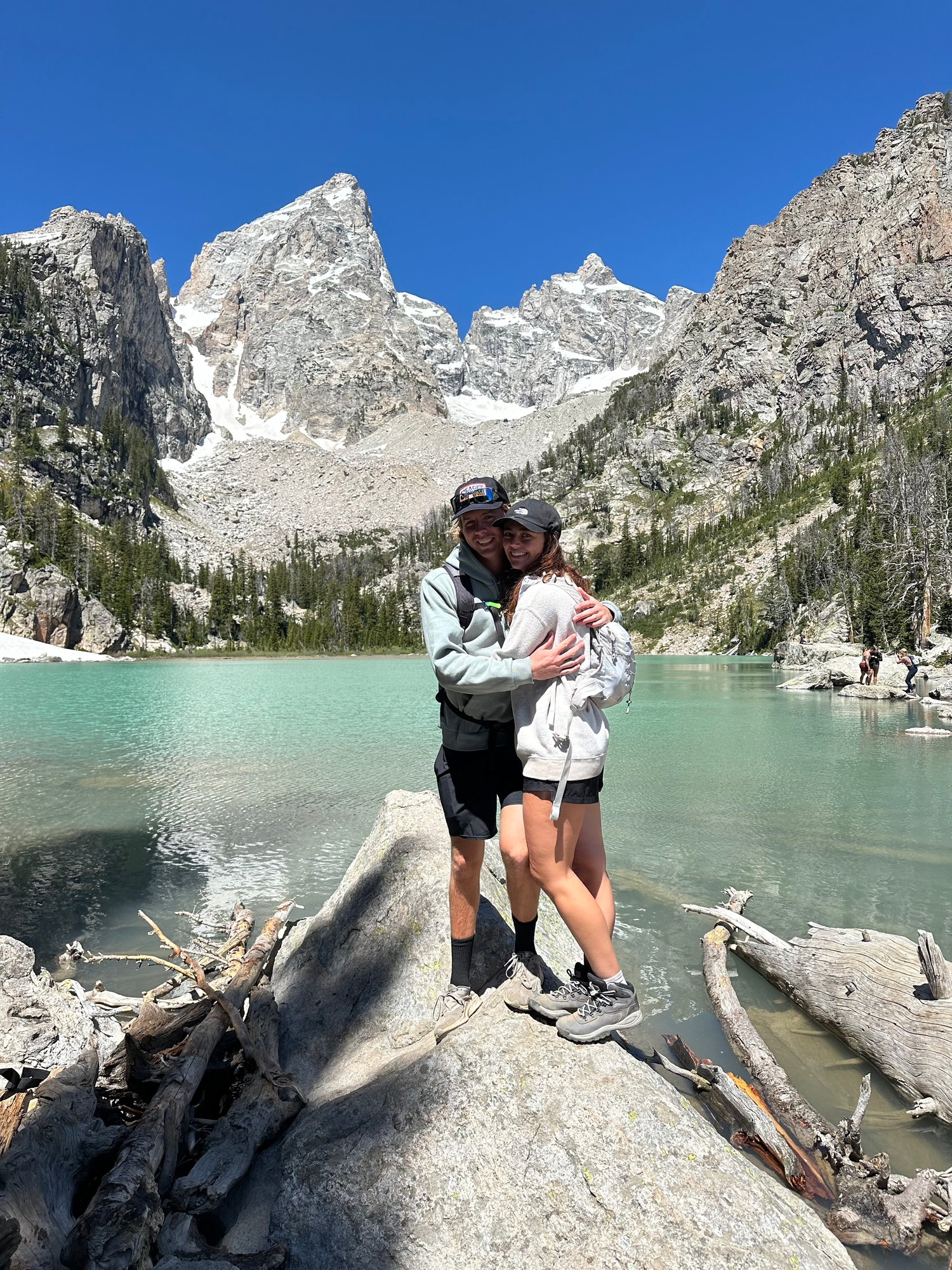 A stunning turquoise alpine lake surrounded by jagged mountain peaks in the wilderness.