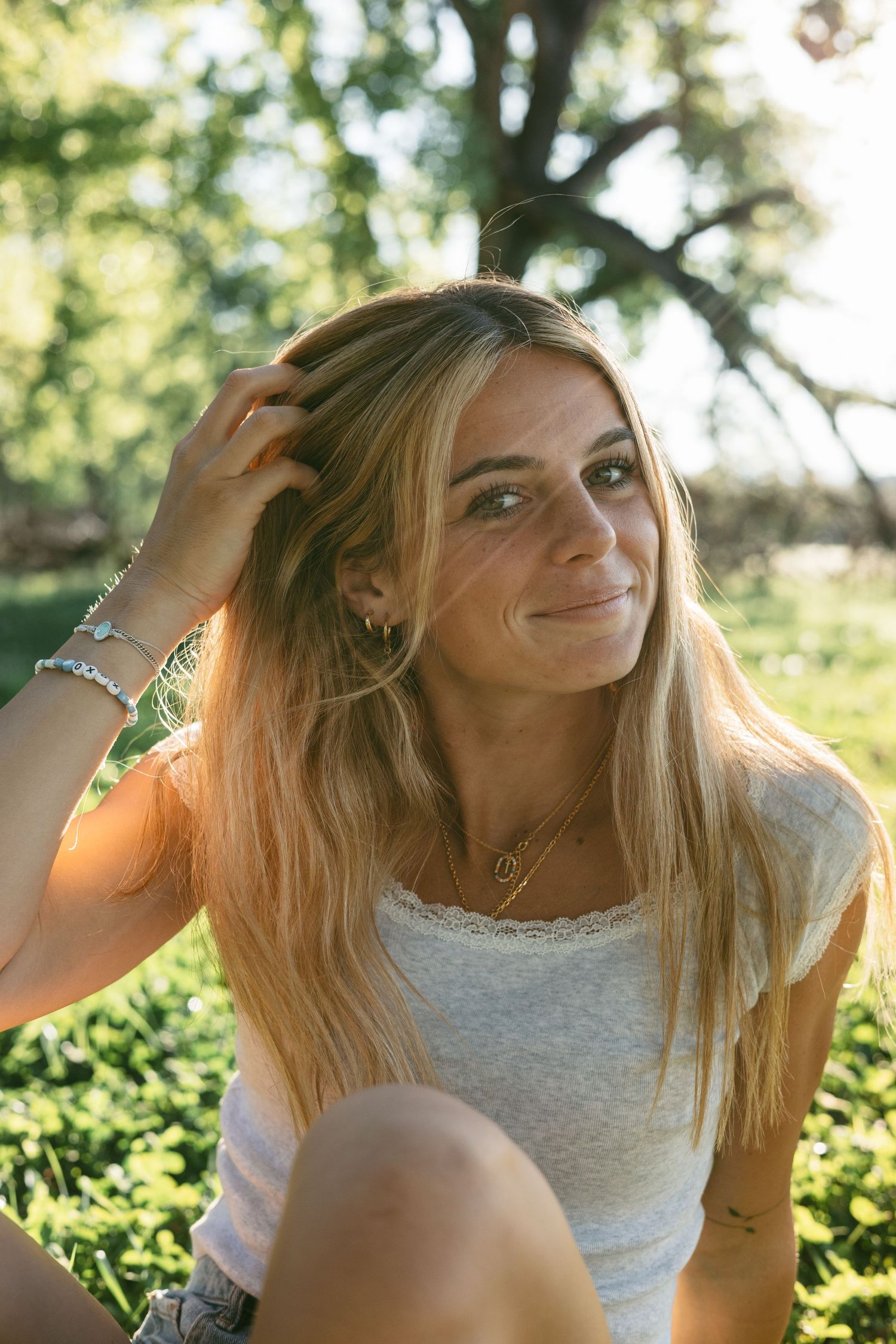 Candid summer portrait with sunlit foliage in the background.