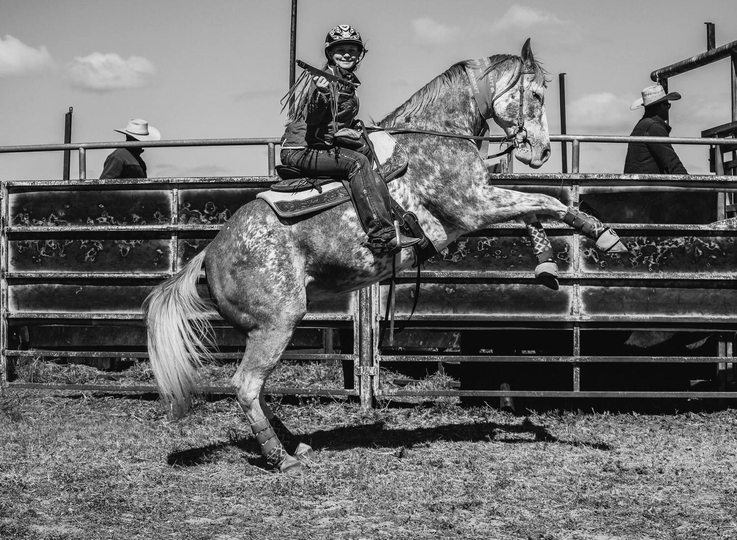 A dramatic black and white sequence of a bull rider being thrown from a bucking bull at a rodeo event.