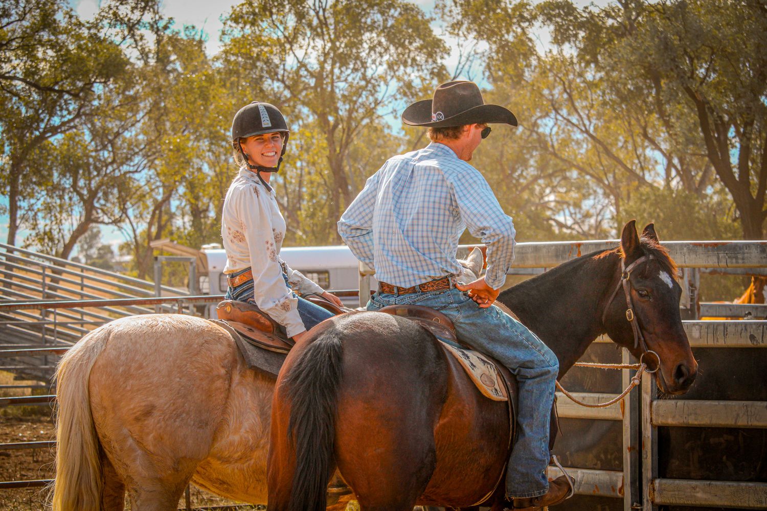 Riders practicing horsemanship skills in a rustic outdoor arena setting.