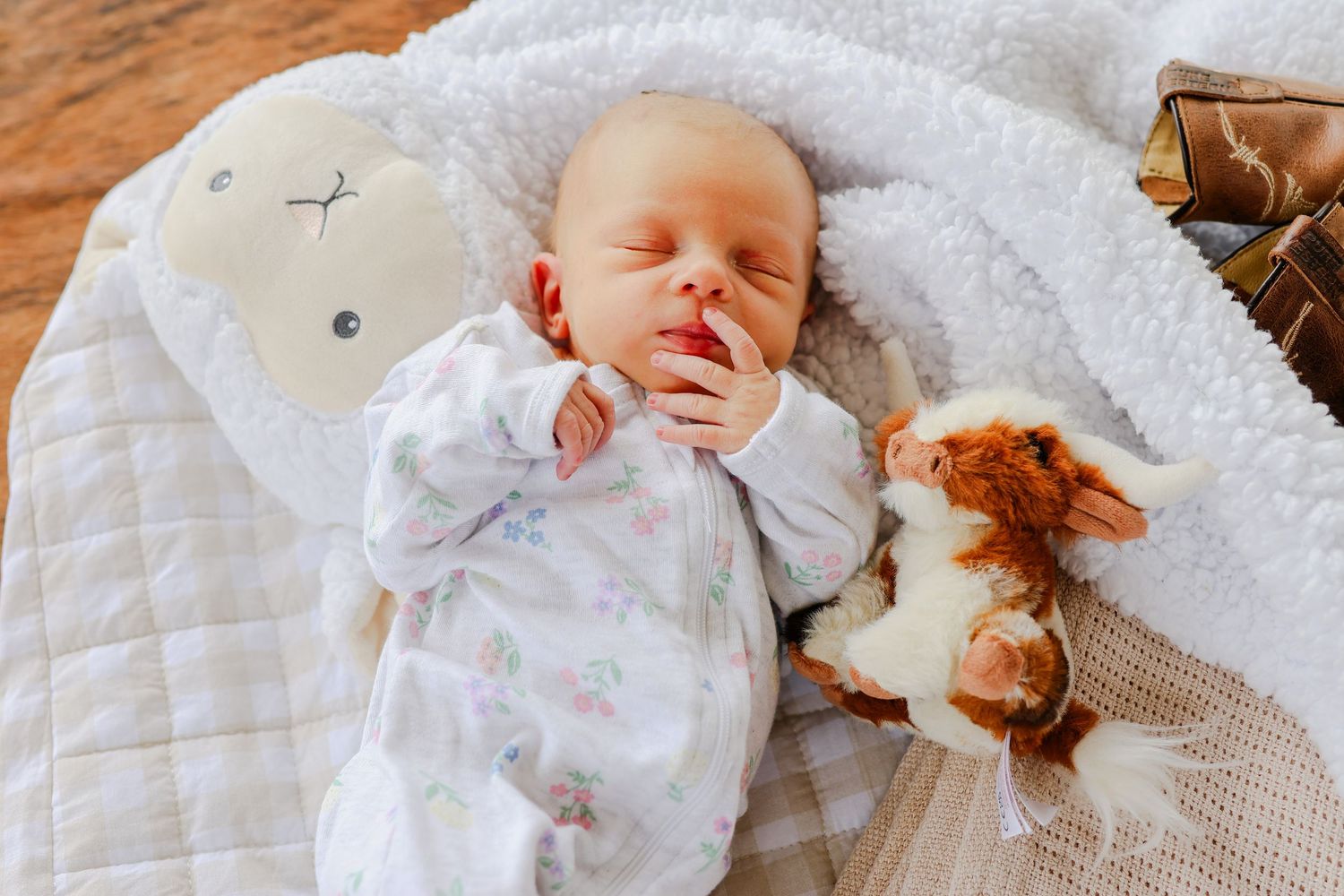 A series of photos showing a sleeping baby wearing white clothing on a quilted surface.