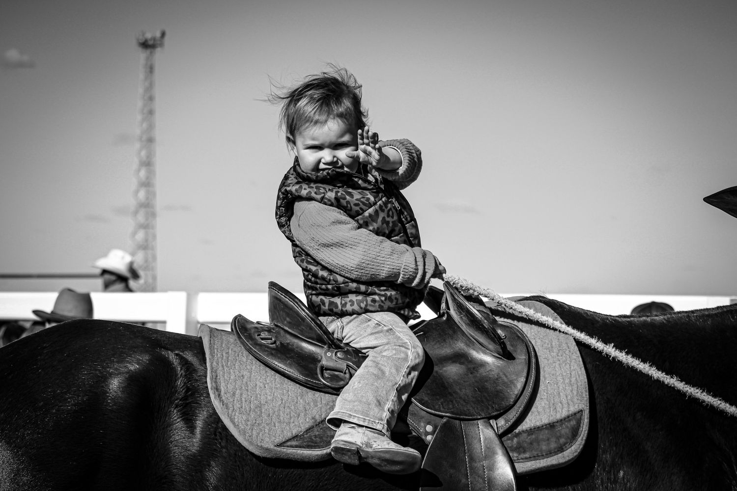 Black and white sequence showing riders practicing roping skills at a western equestrian event.