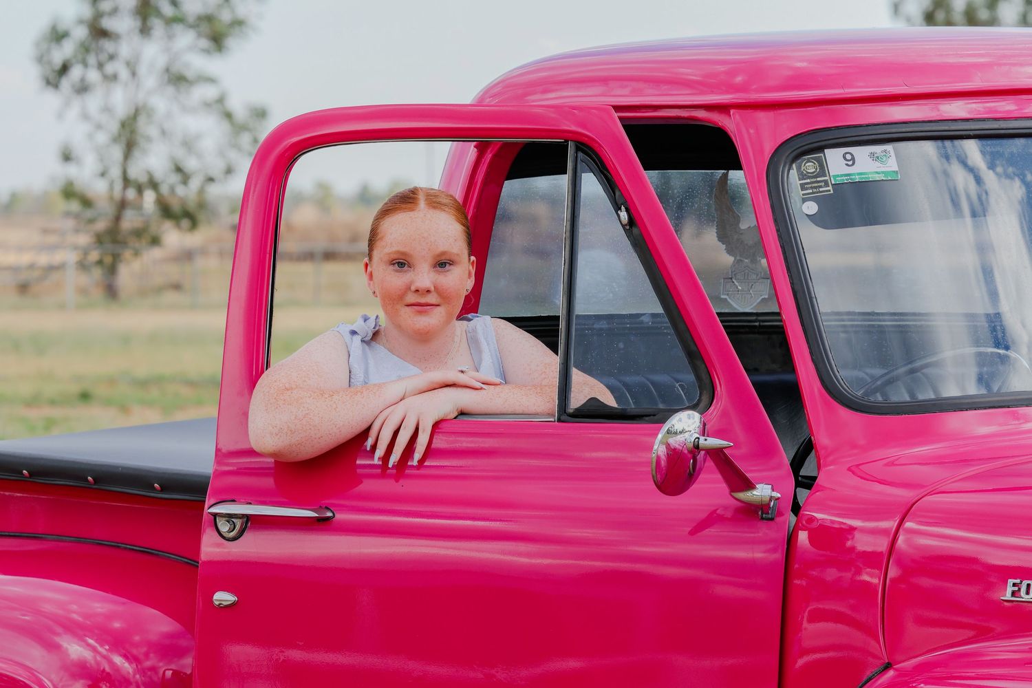 A bright pink vintage pickup truck is shown in a series of connected photos in a desert landscape setting.