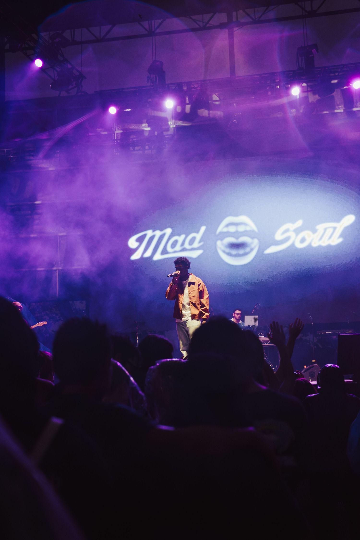 Performer on stage at Mad Soul concert with purple lighting and fog filling the venue.