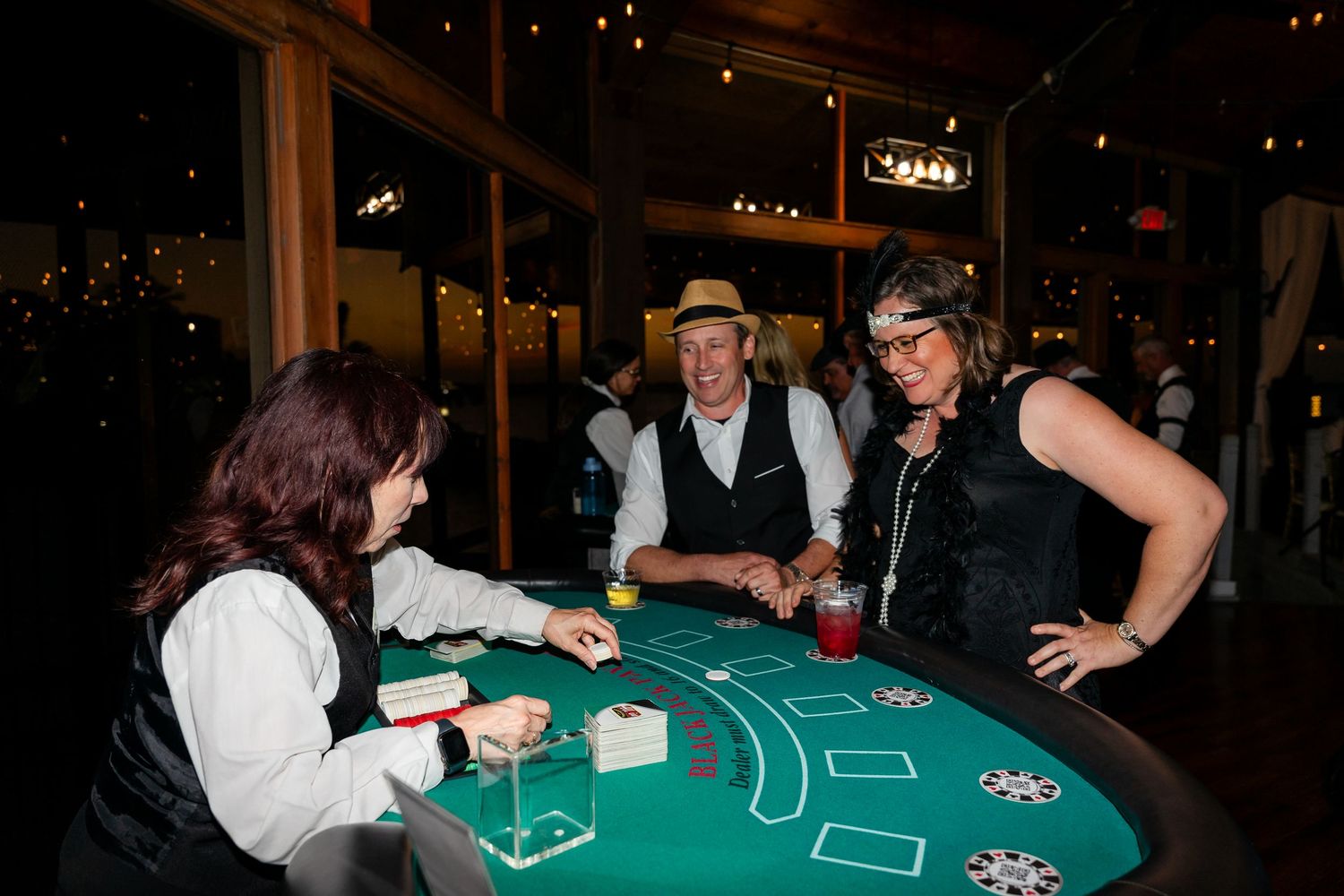 Guests playing blackjack at a 1920s-themed casino night event in an elegant venue.