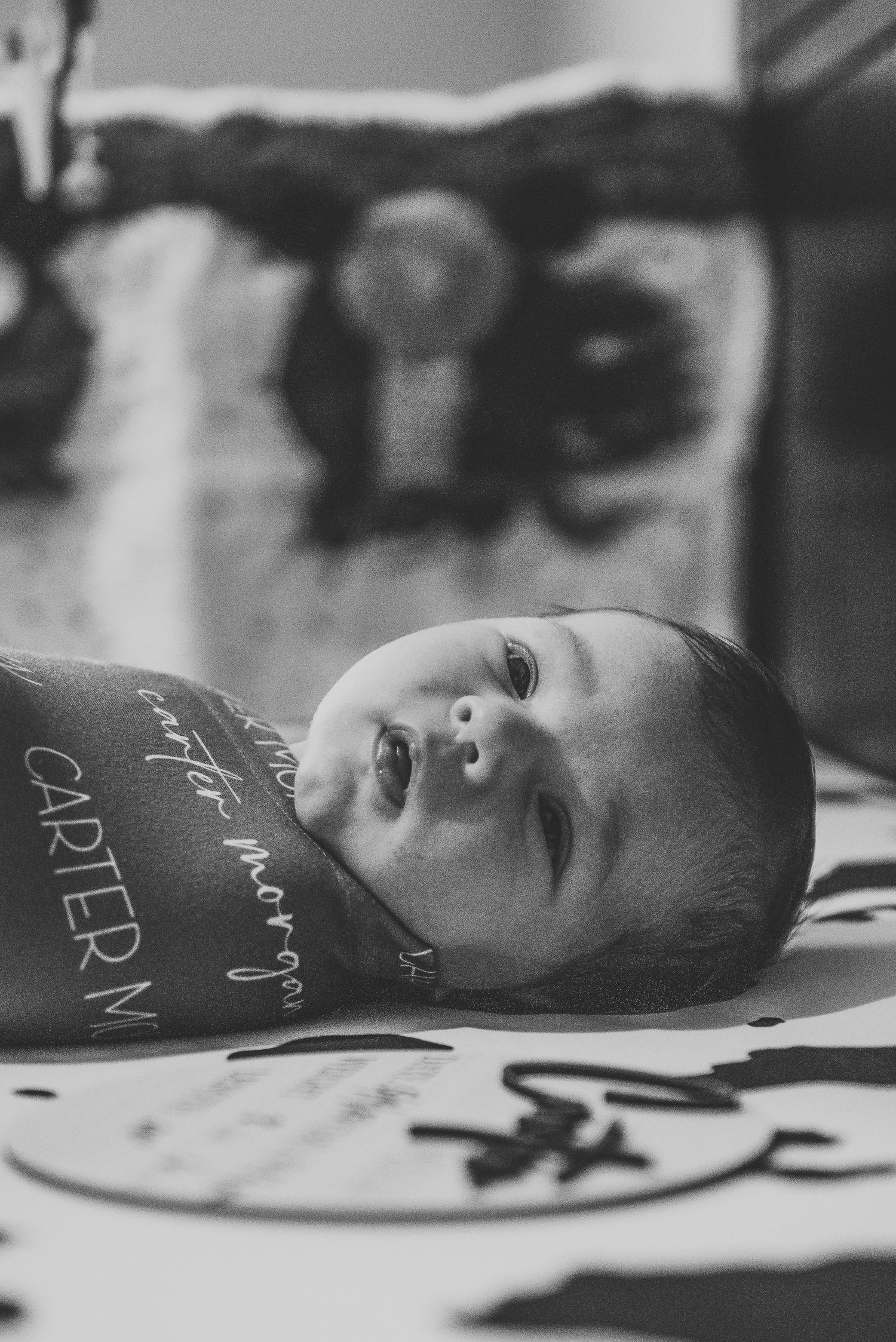 Black and white photo of newborn baby Carter Morgan swaddled in personalized blanket.
