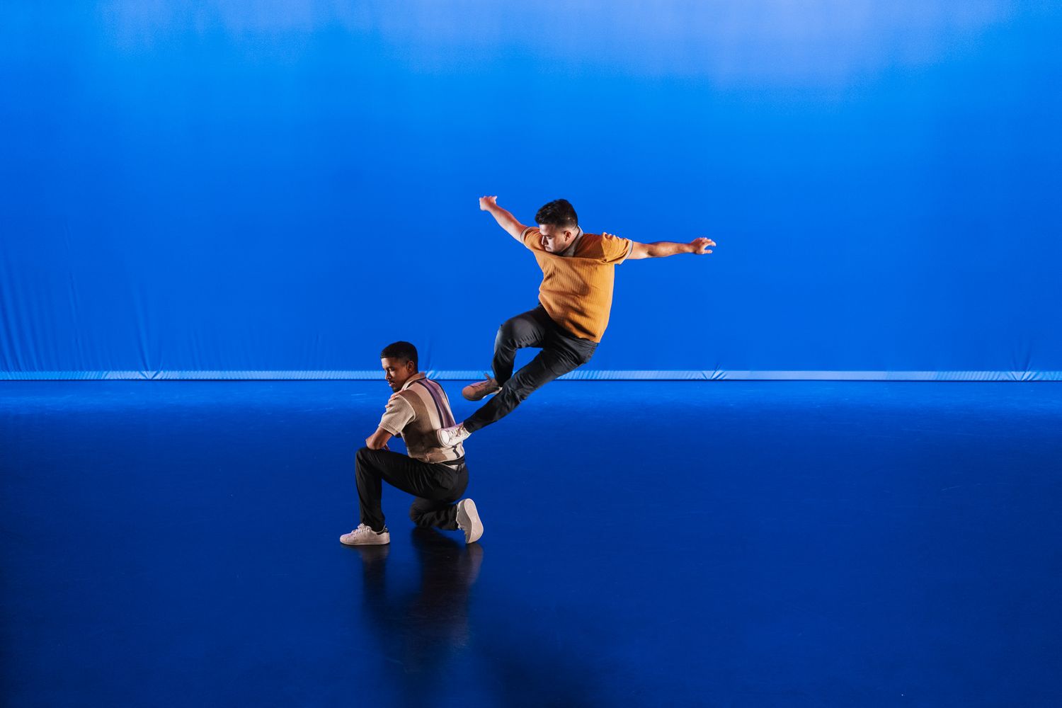 A series of eight athletic diving figures against a deep blue background performing synchronized diving movements.