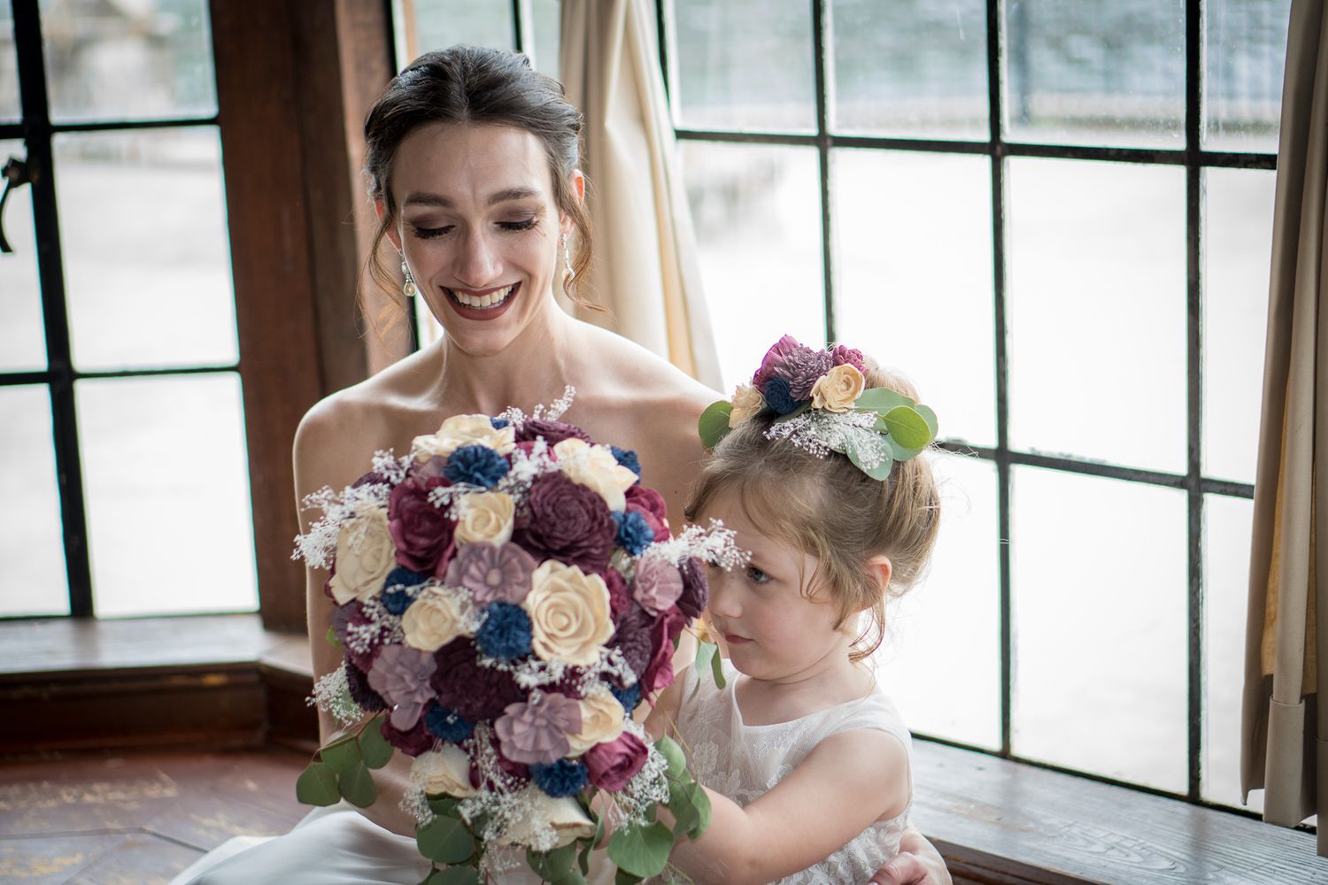 Joyful indoor wedding moments captured near large windows with natural light.