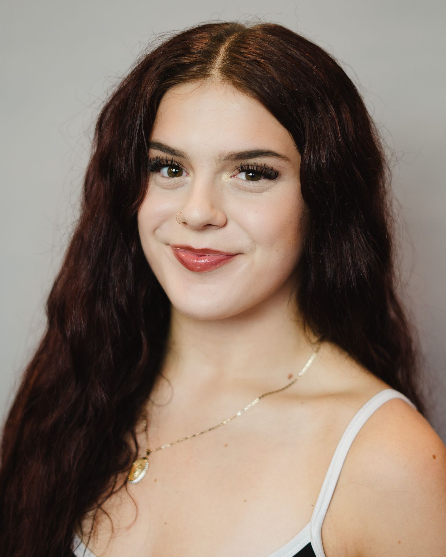 Studio portrait sequence showing dark hair and natural makeup against grey background.