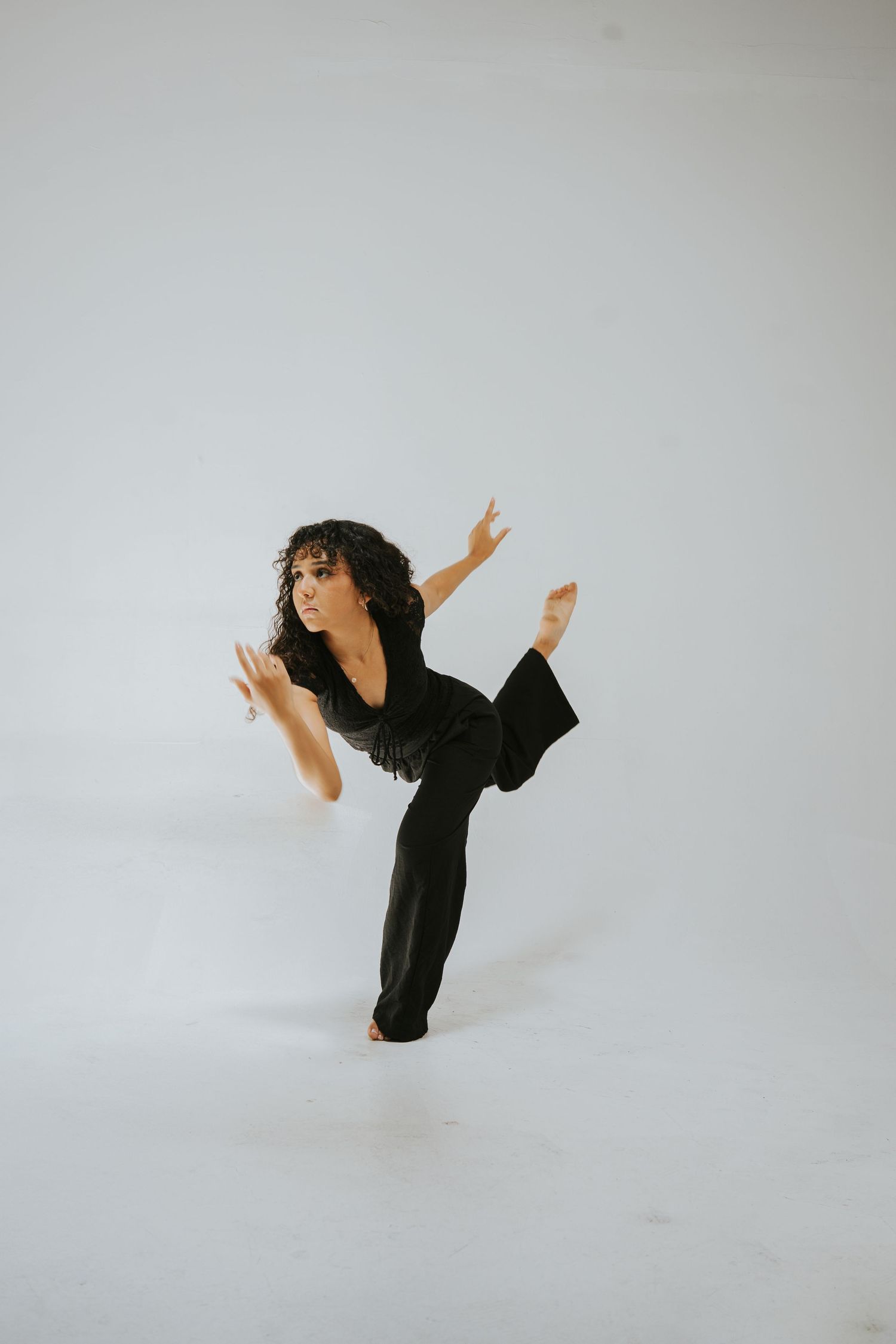 Modern dance performance featuring dramatic poses in black attire on white stage.