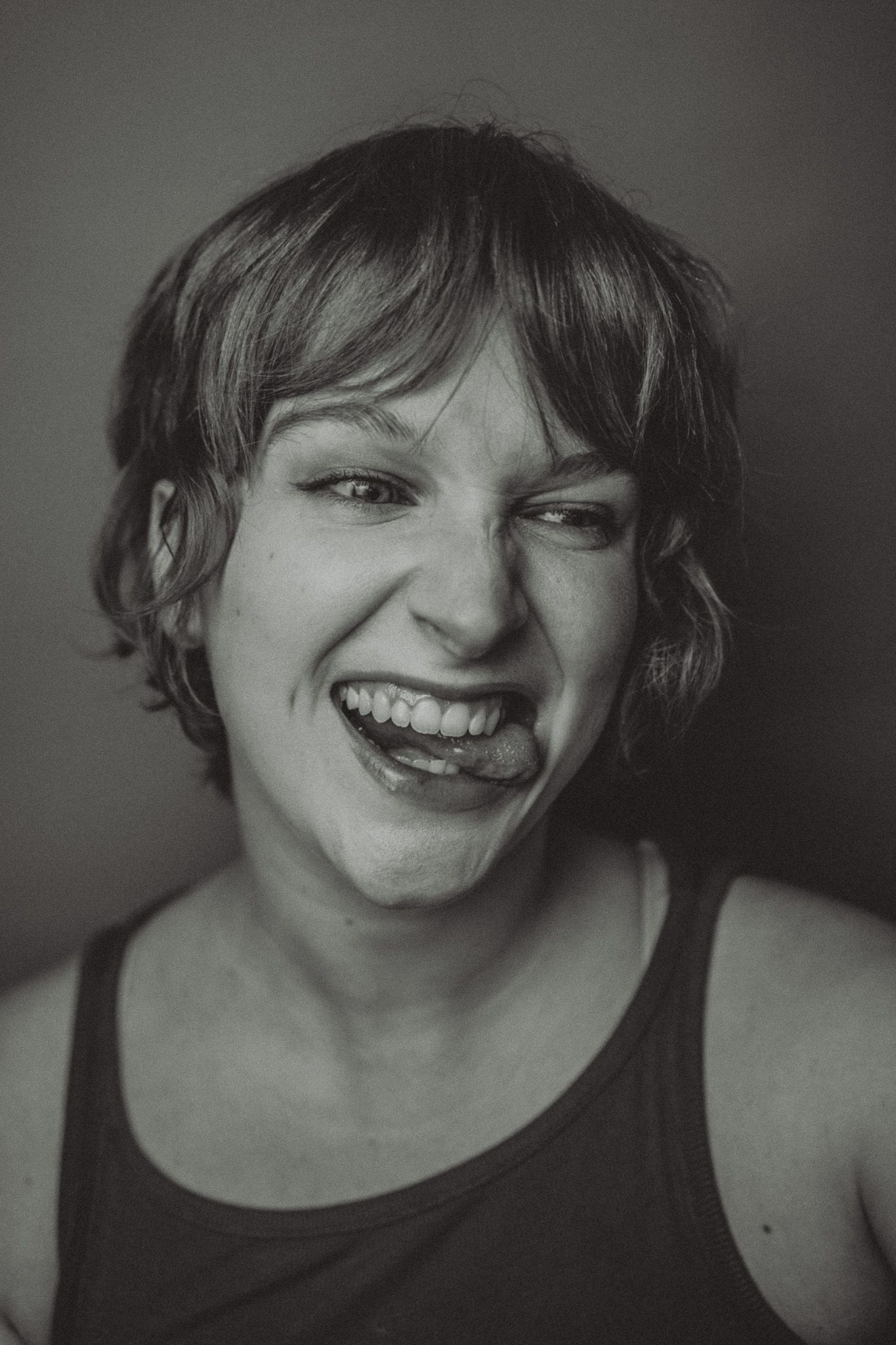 A series of four black and white portrait photographs showing joyful expressions and genuine laughter.
