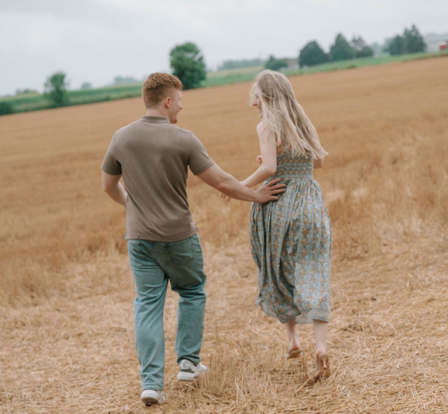 A couple frolicking in a wheat field