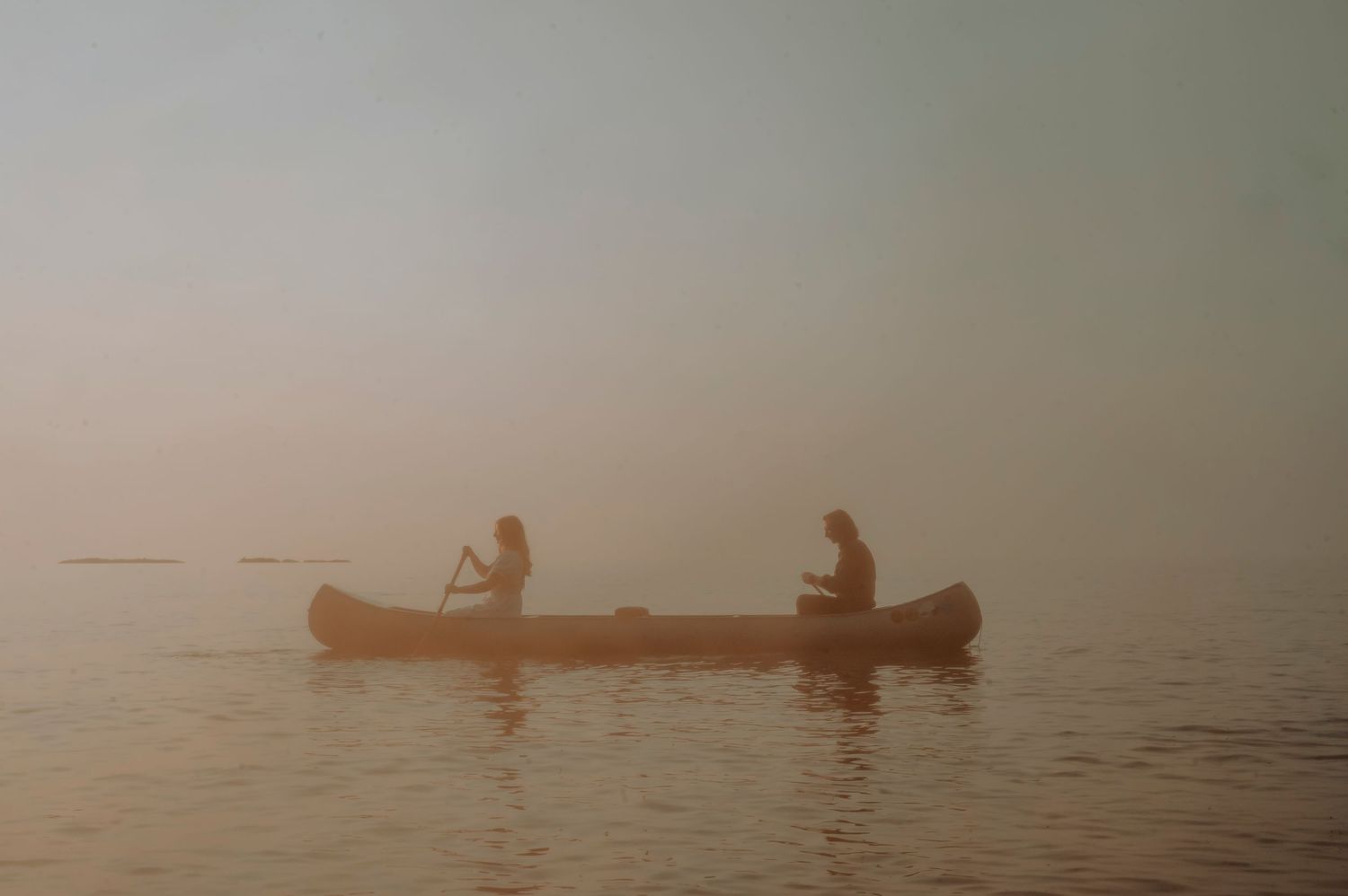 A couple paddles in a canoe
