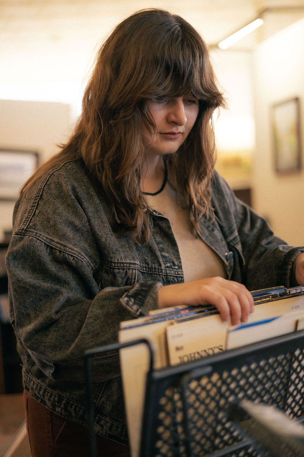 A woman rummages through a collection of old vinyls