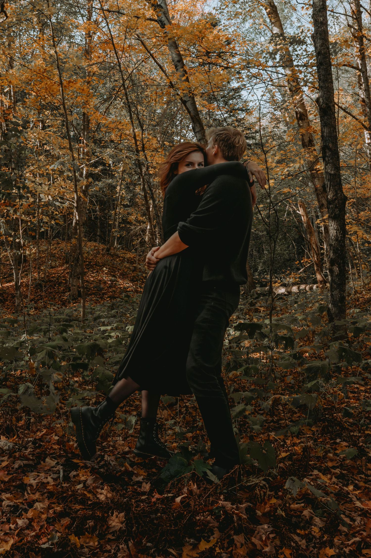 A couple spinning around in an autumnal forest