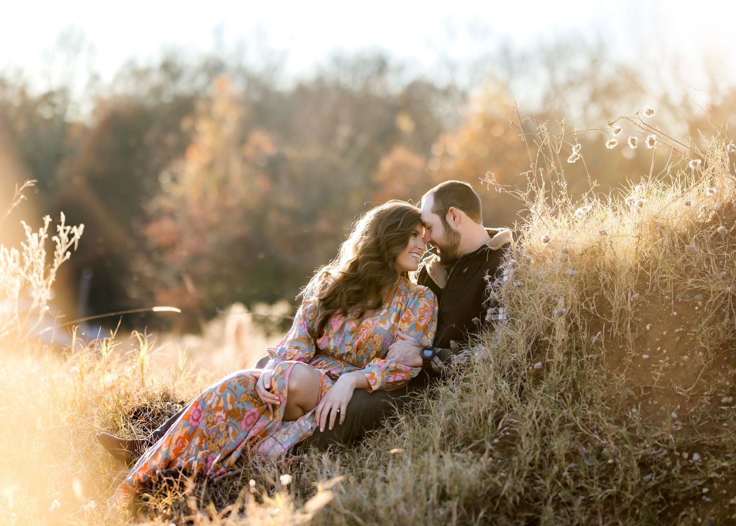 Intimate couple moment in golden field during sunset.