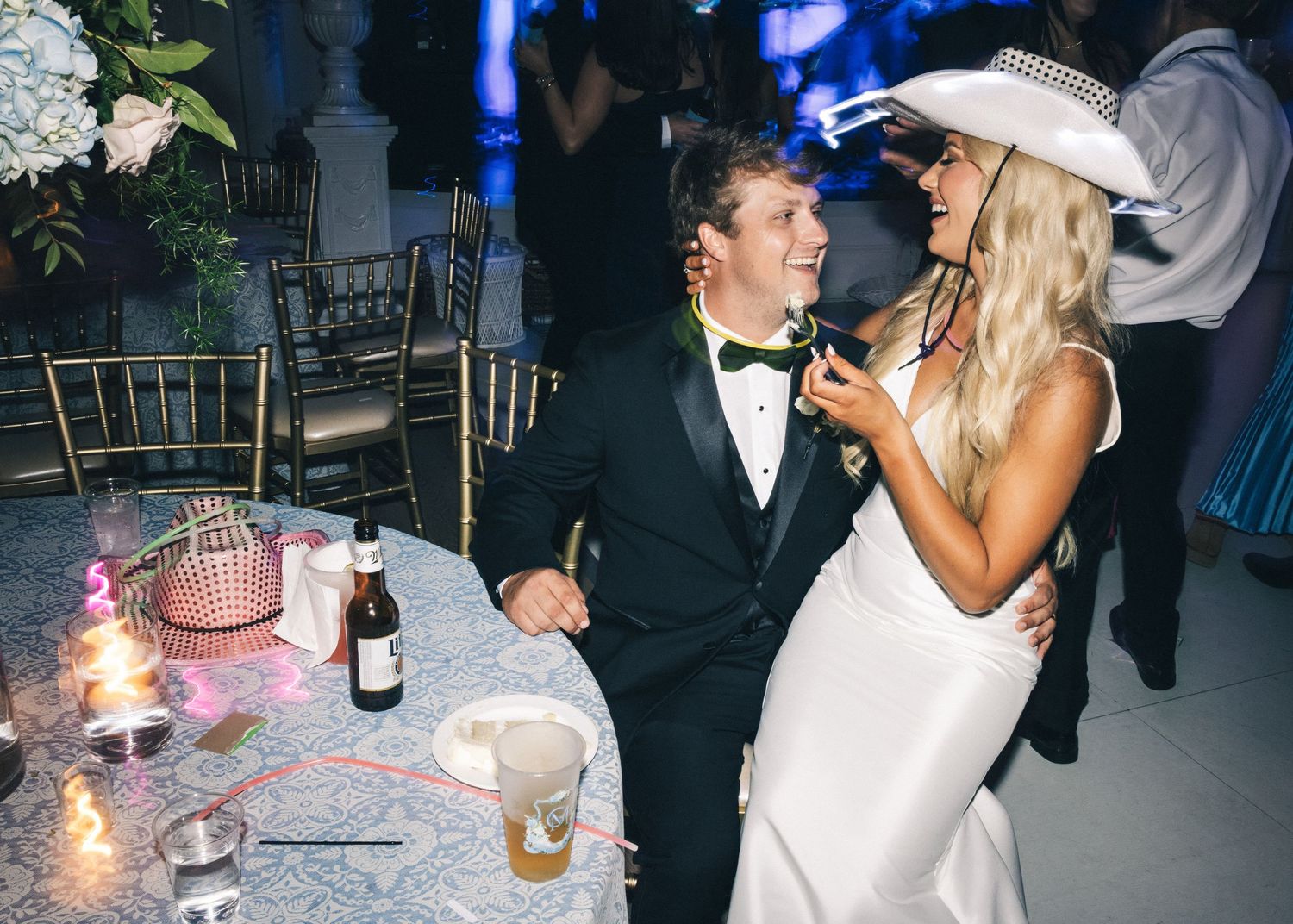 Wedding reception scene with blue lighting and champagne toasts.