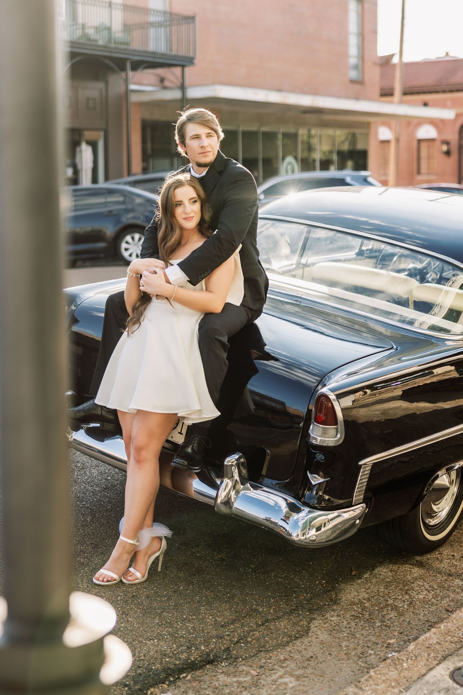 Stylish engagement photos featuring a classic vintage car and formal attire.