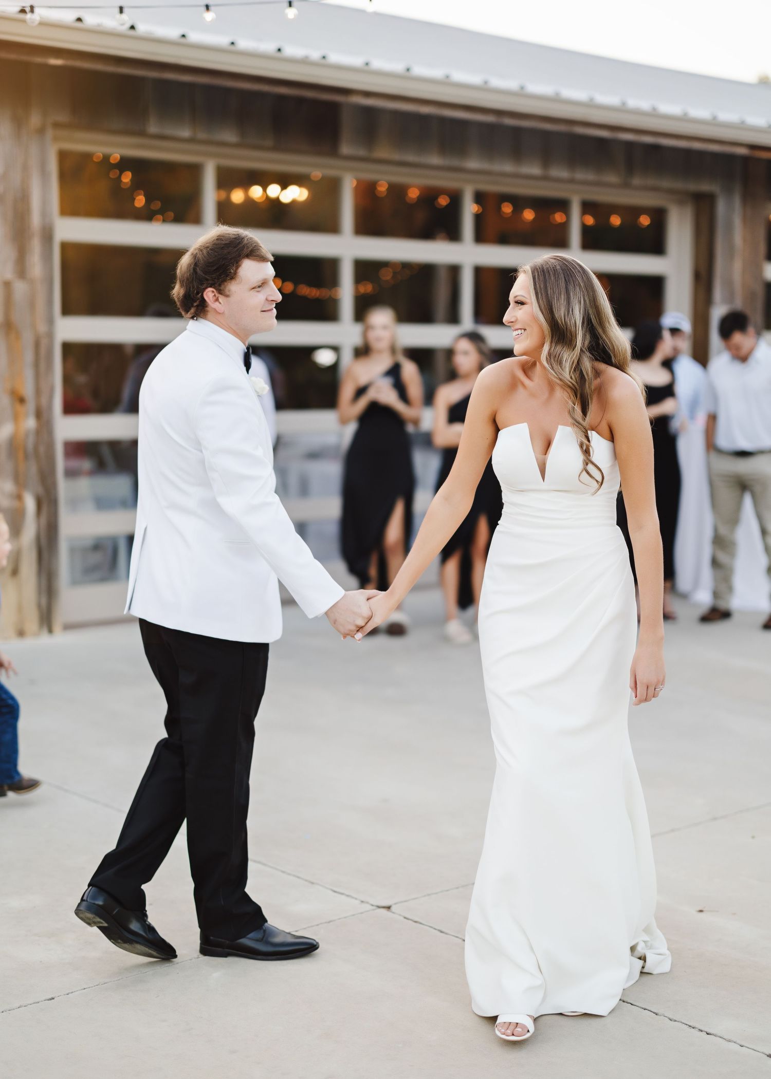 Wedding celebration with guests dancing on an outdoor patio.