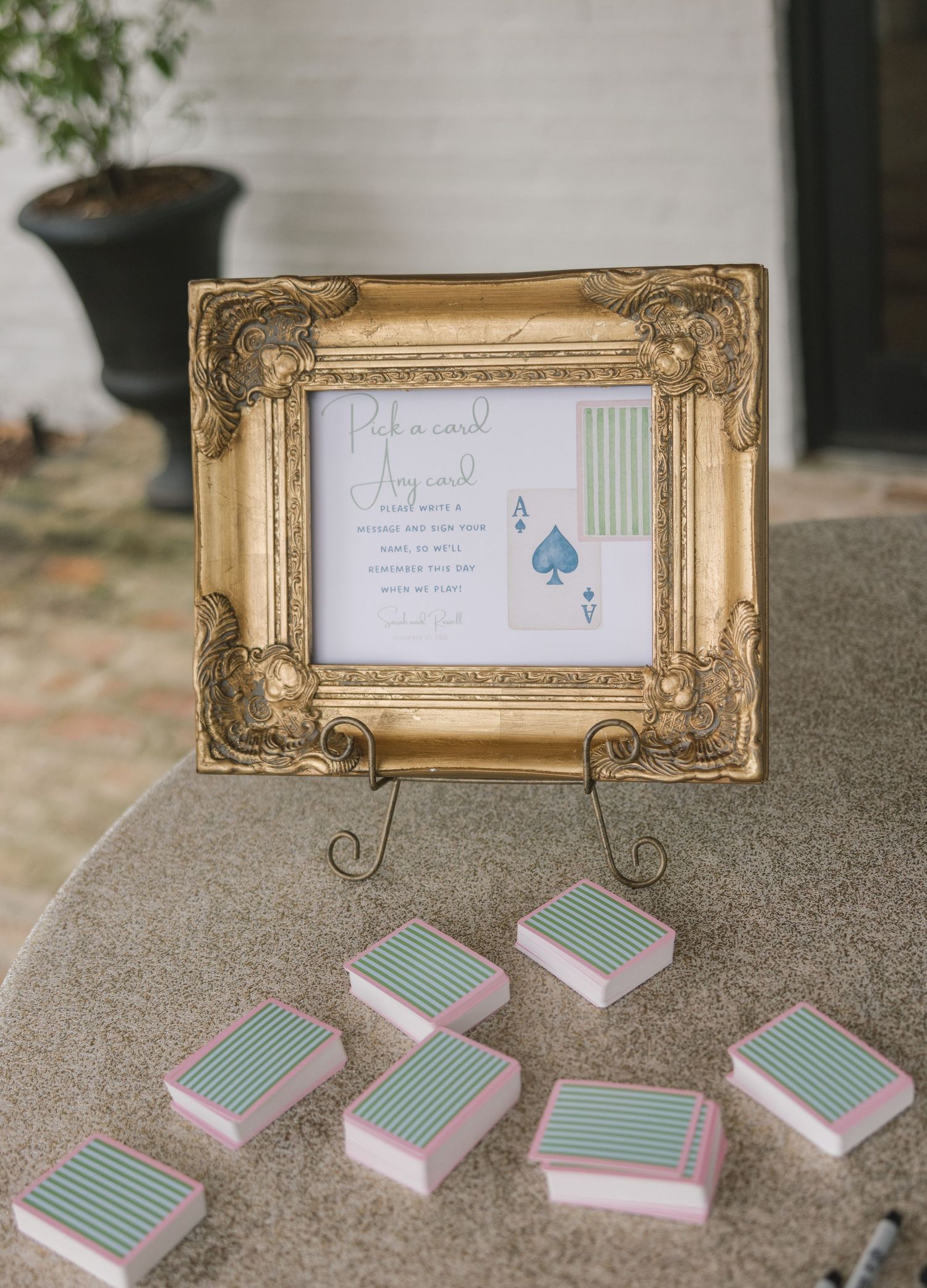 Vintage gold frames display elegant signs and mint green playing card decks arranged on a textured stone surface.