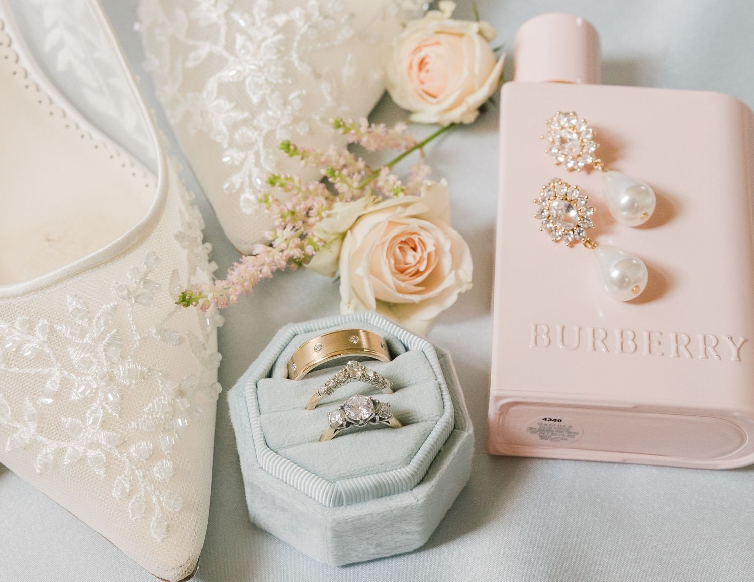 Delicate wedding accessories including blush roses and jewelry boxes in pastel colors.