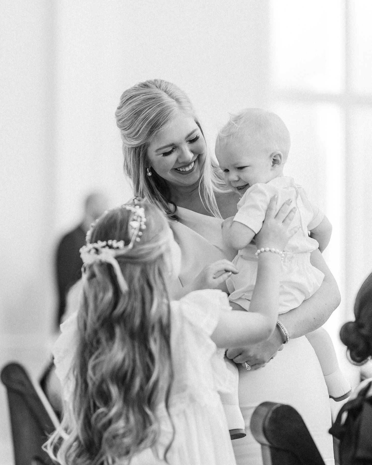 Tender black and white moments shared with a baby during wedding celebrations.