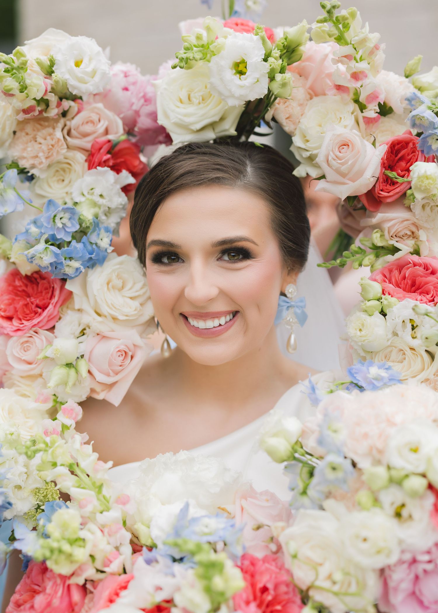 A floral frame adorned with coral and white roses, blue hydrangeas, and delicate greenery creates a romantic garden setting.
