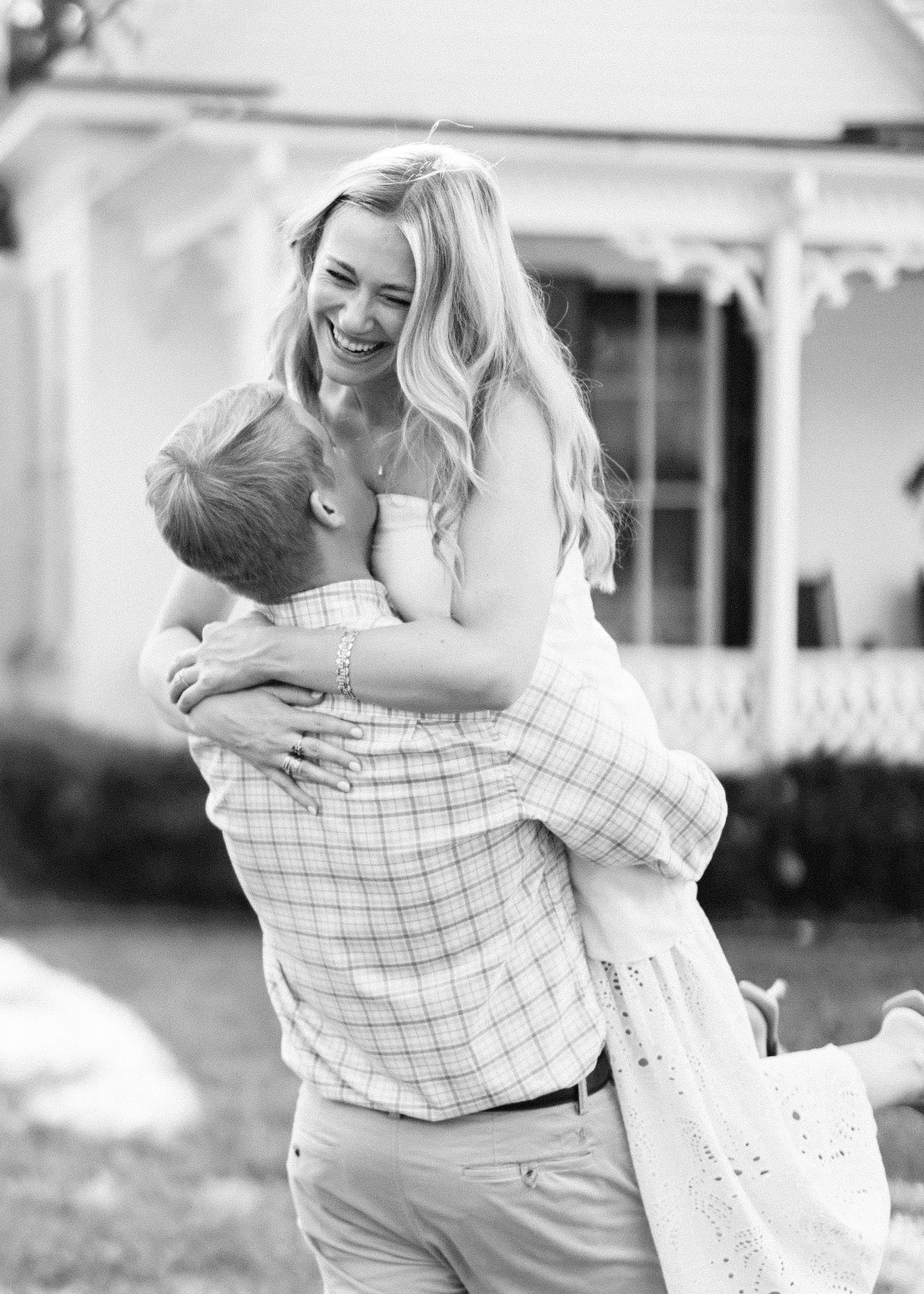Black and white photo sequence showing a couple in a joyful embrace outdoors near a house.