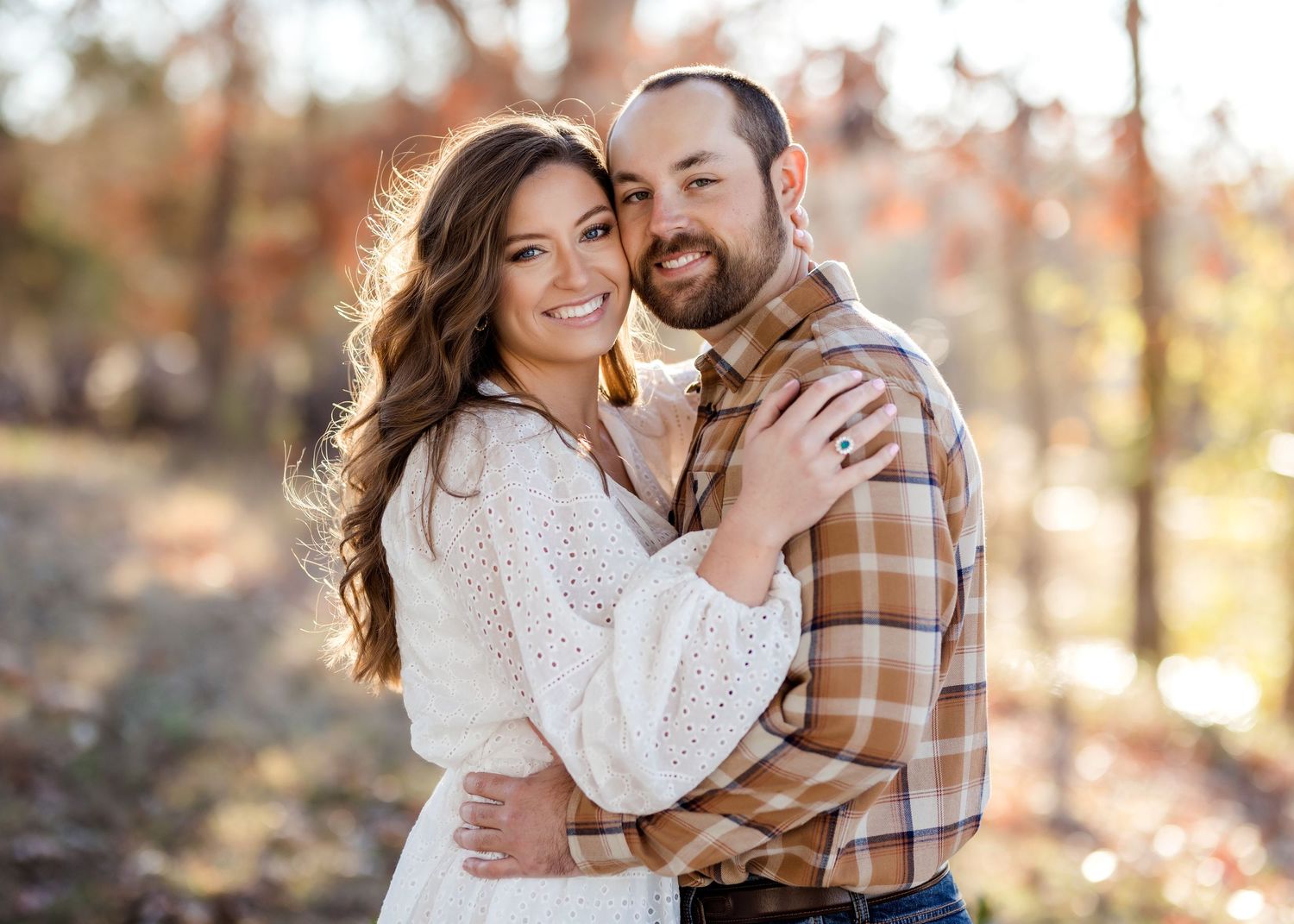 Sweet couple embracing outdoors during autumn photoshoot.