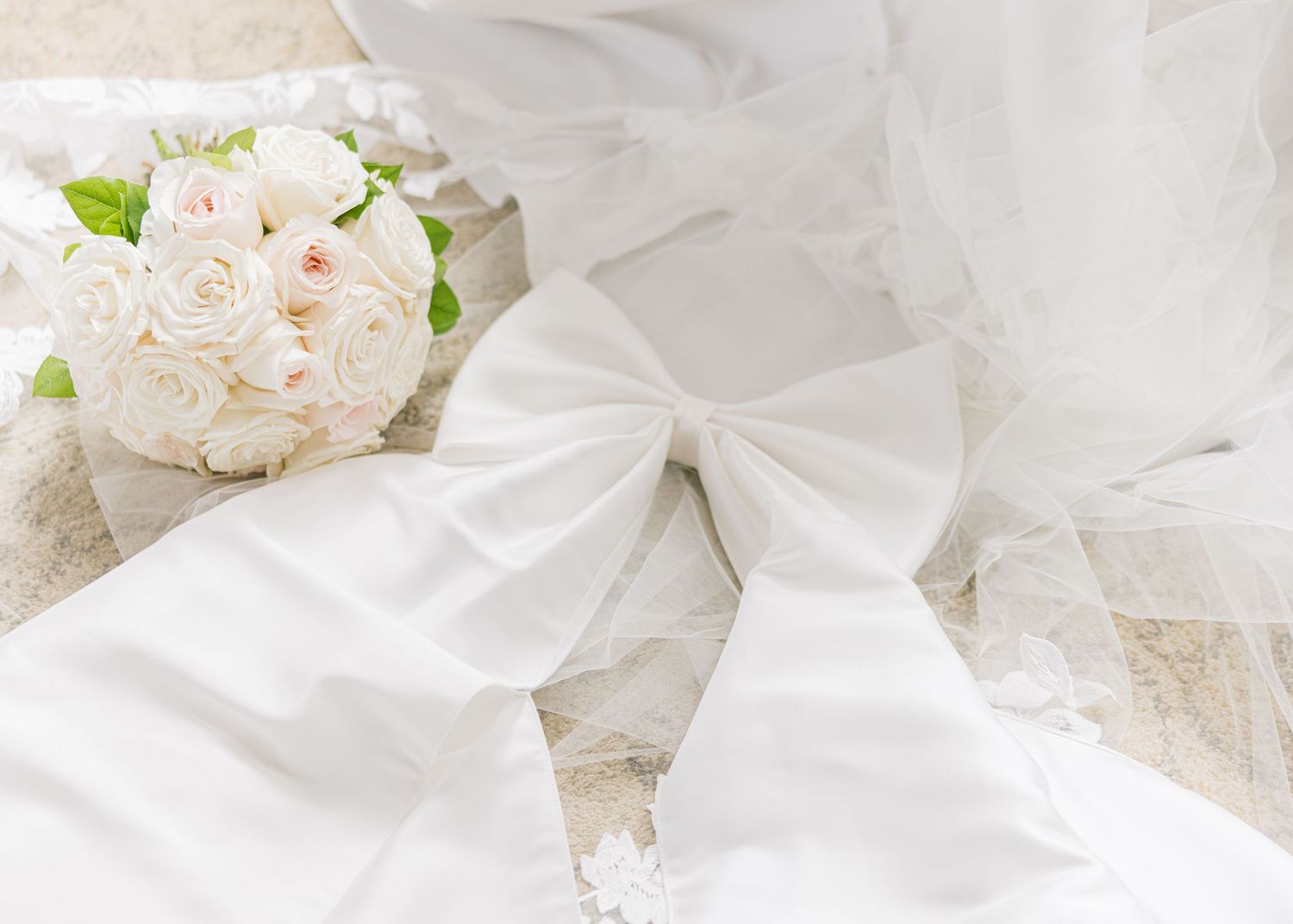 Delicate white silk fabric and soft pink roses create an elegant wedding or bridal styled composition.